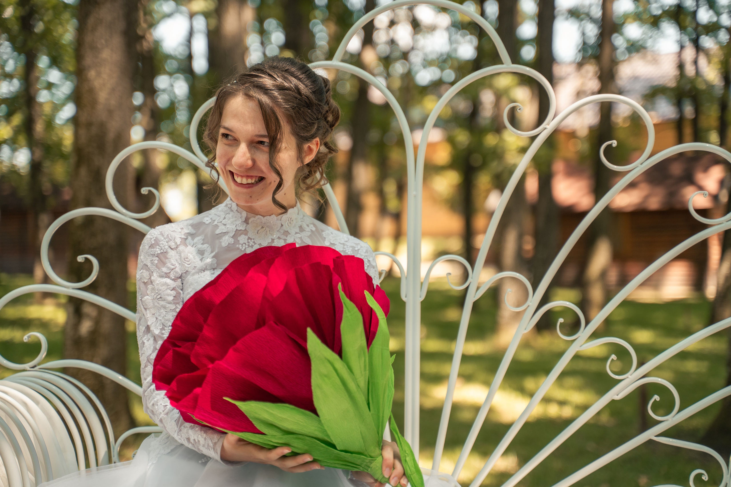 Portret creativ cuplu nuntă, mireasă ținând un trandafir roșu supradimensionat, moment haios nuntă în aer liber, incadru.ro.