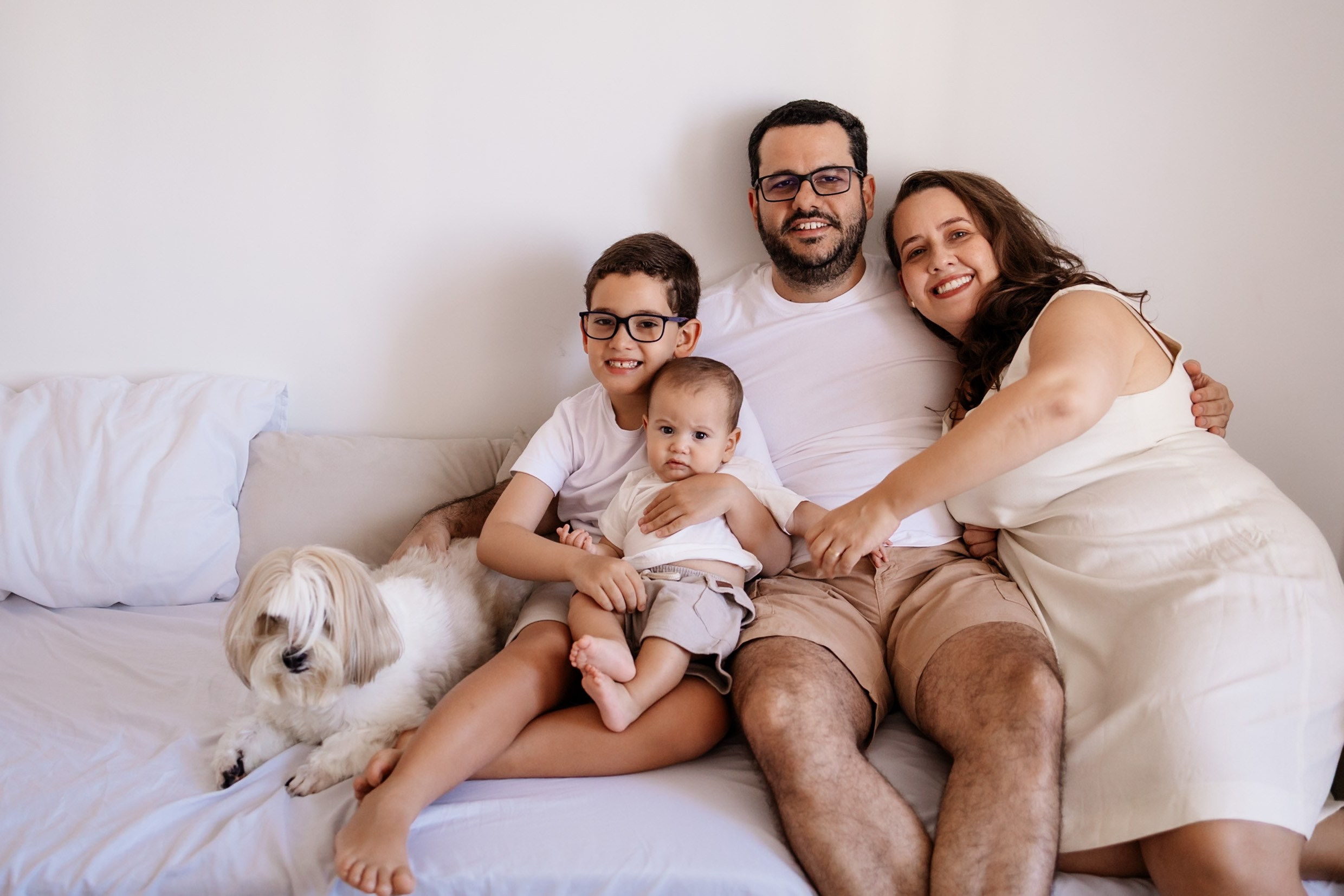 Pais e bebê em momento calmo no ensaio familiar.