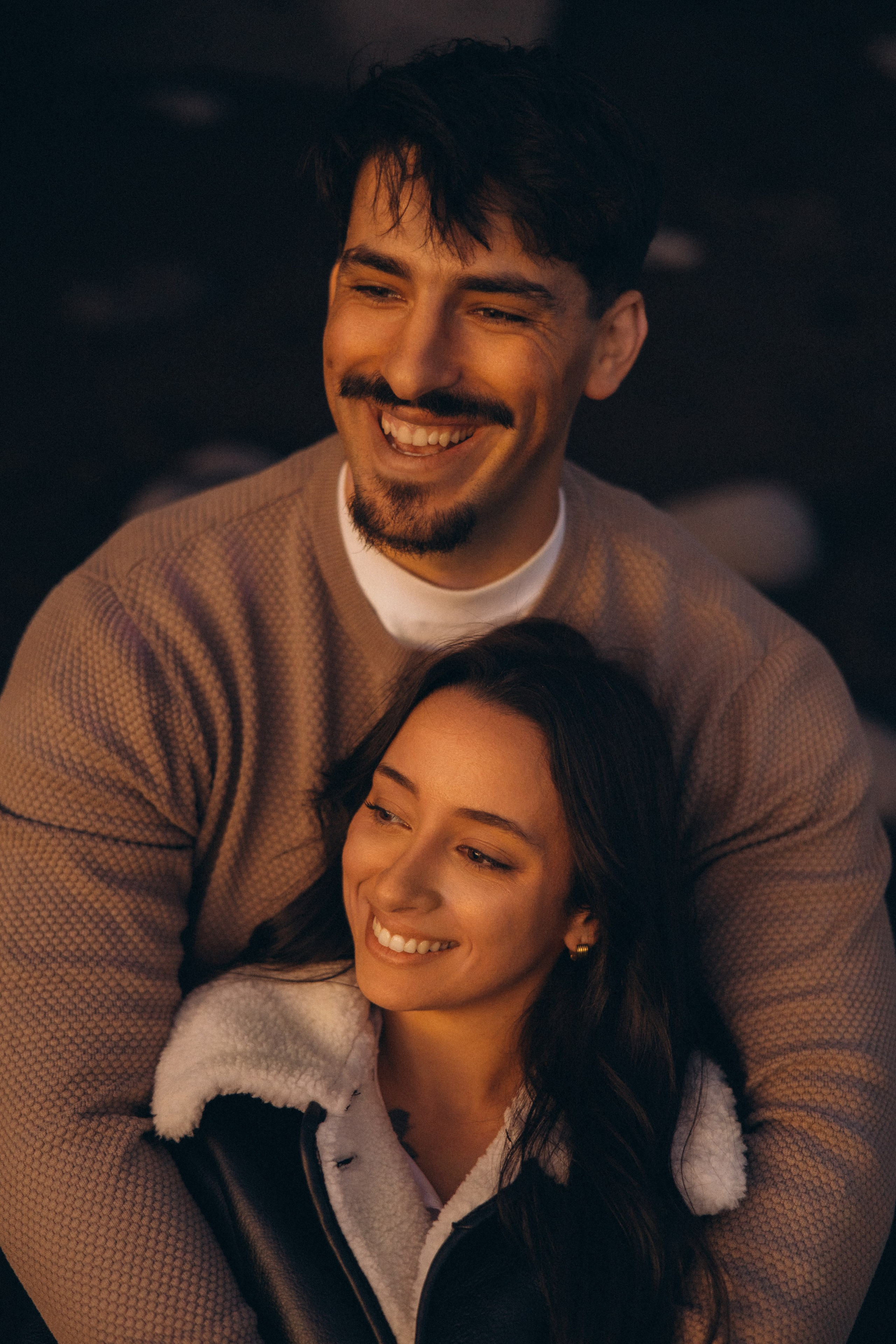 Couple sharing a romantic moment during sunset on Madeira Island, with the ocean and cliffs in the background