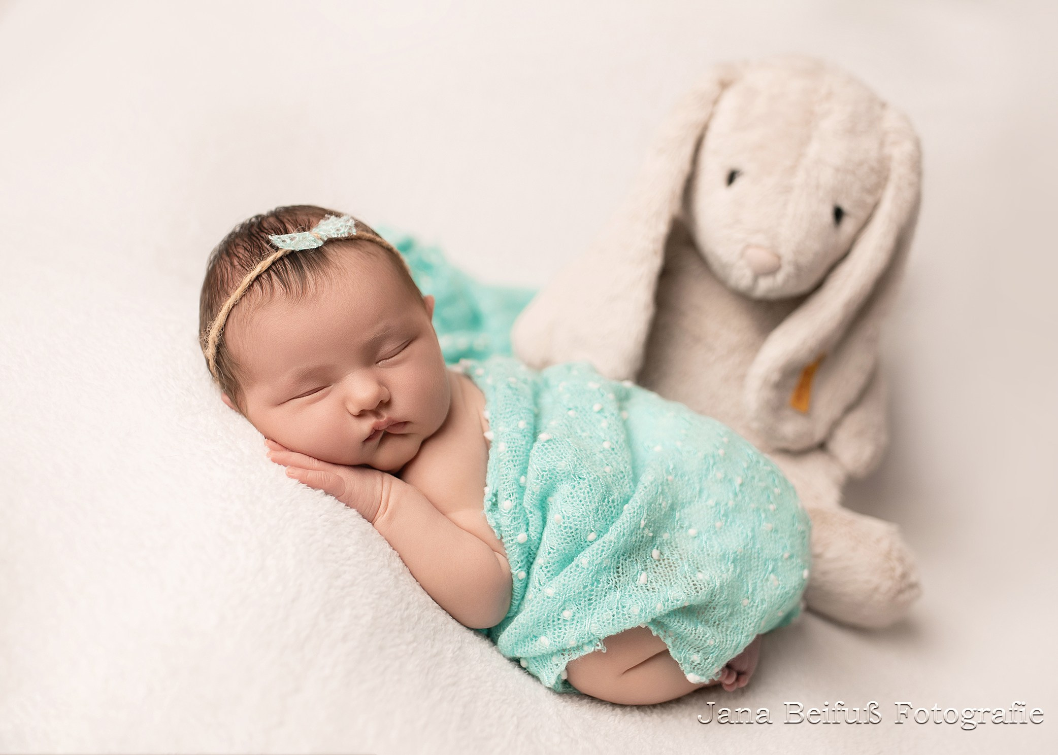 Baby schläft gemütlich auf weißem Tuch mit Hase Kuscheltier - Fotografie Ulm - Weißenhorn und Umgebung