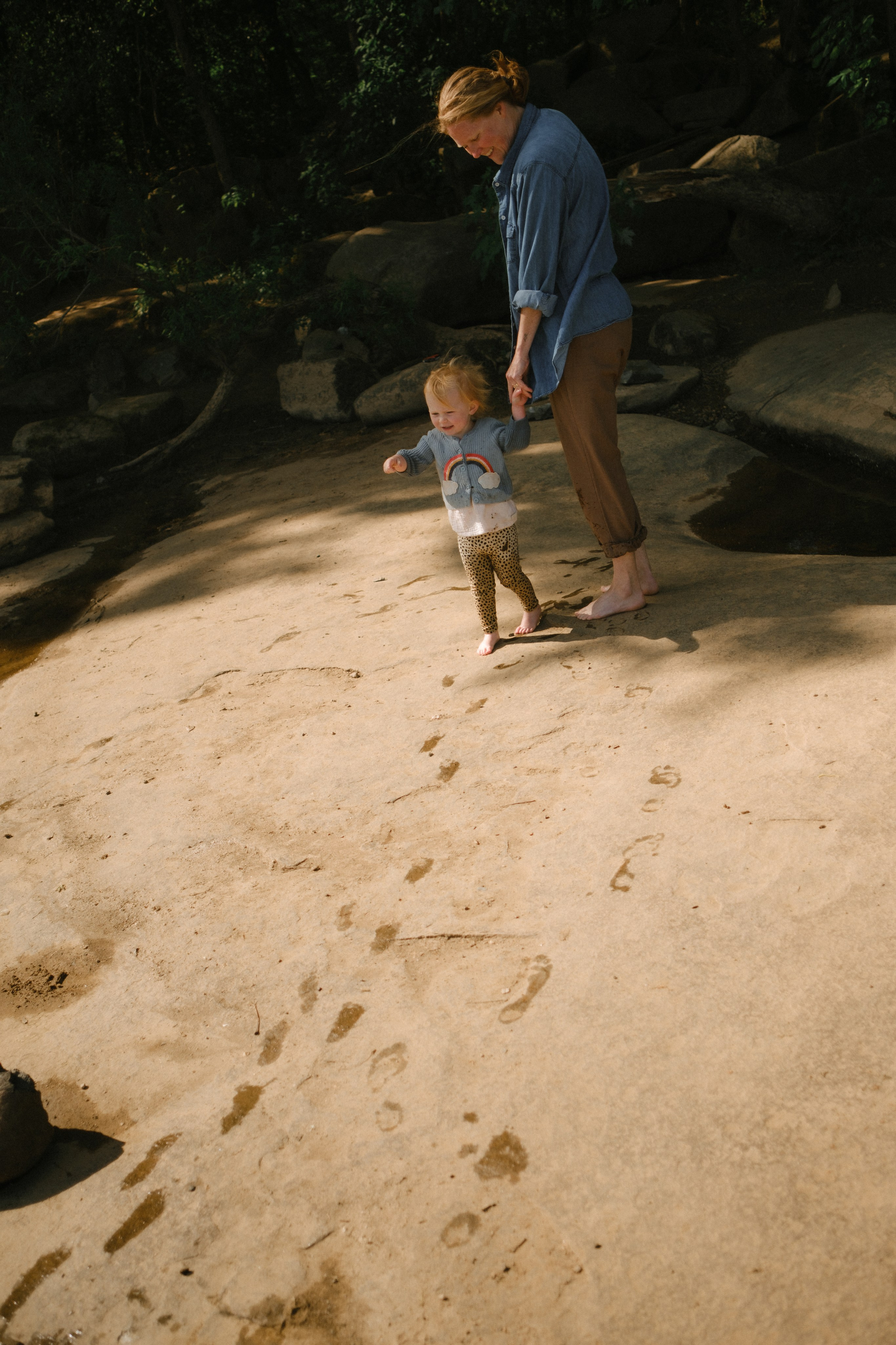Artistic family photography playing with natural light and dramatic shadows on the river rocks at the James River