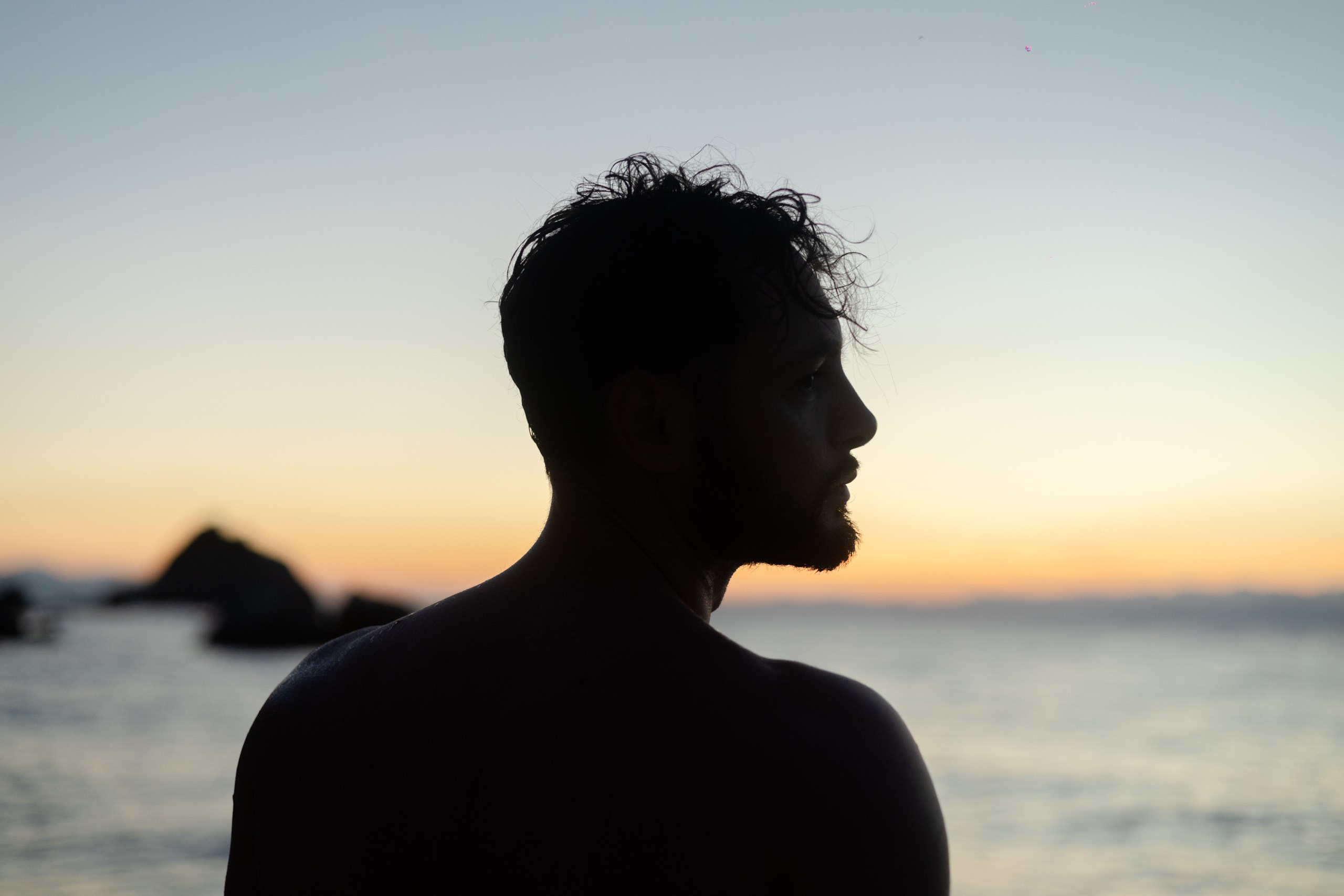 Portrait of a man standing on the beach at sunset