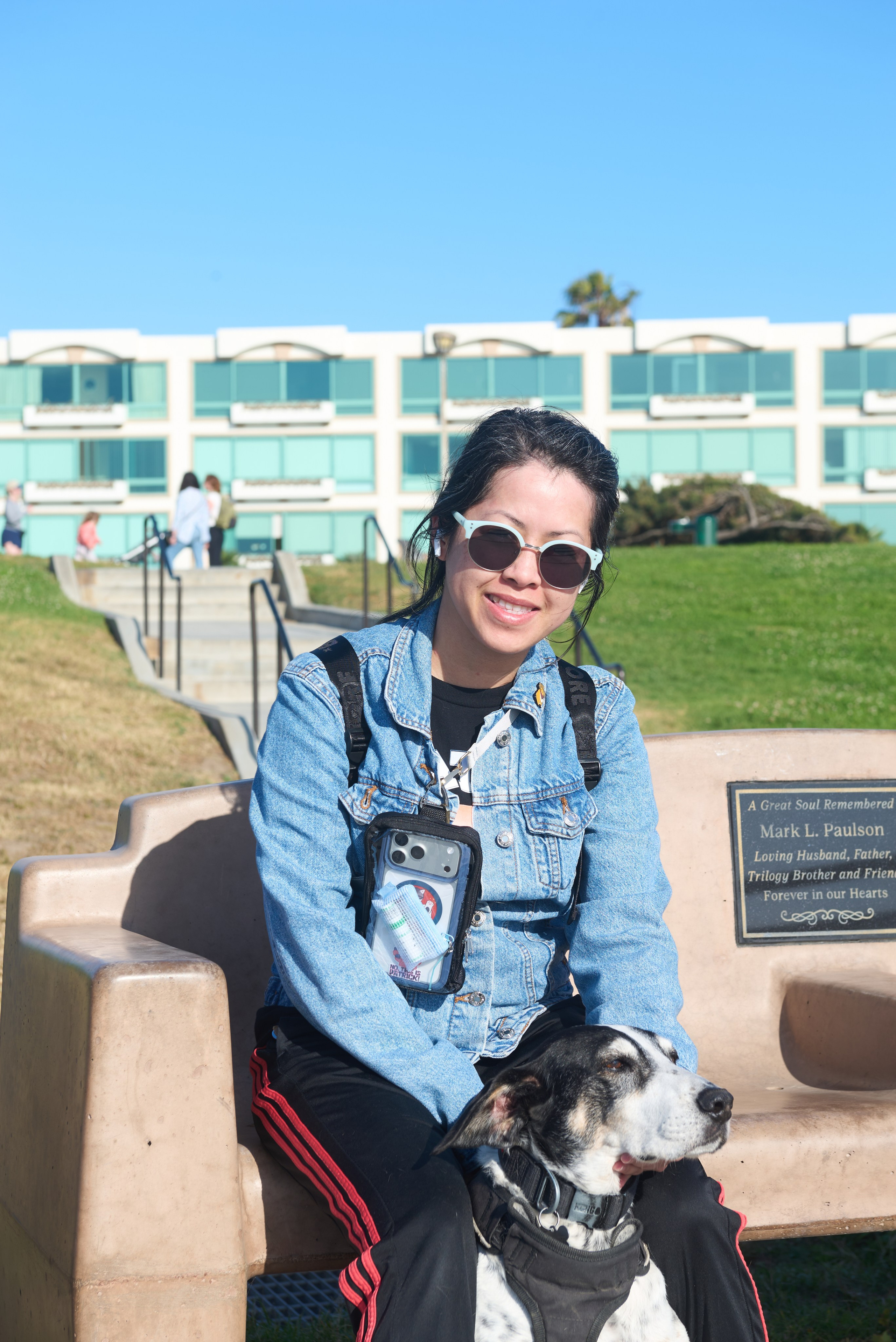 Young woman holding her small white dog during a candid pet photography session in Redondo Beach
