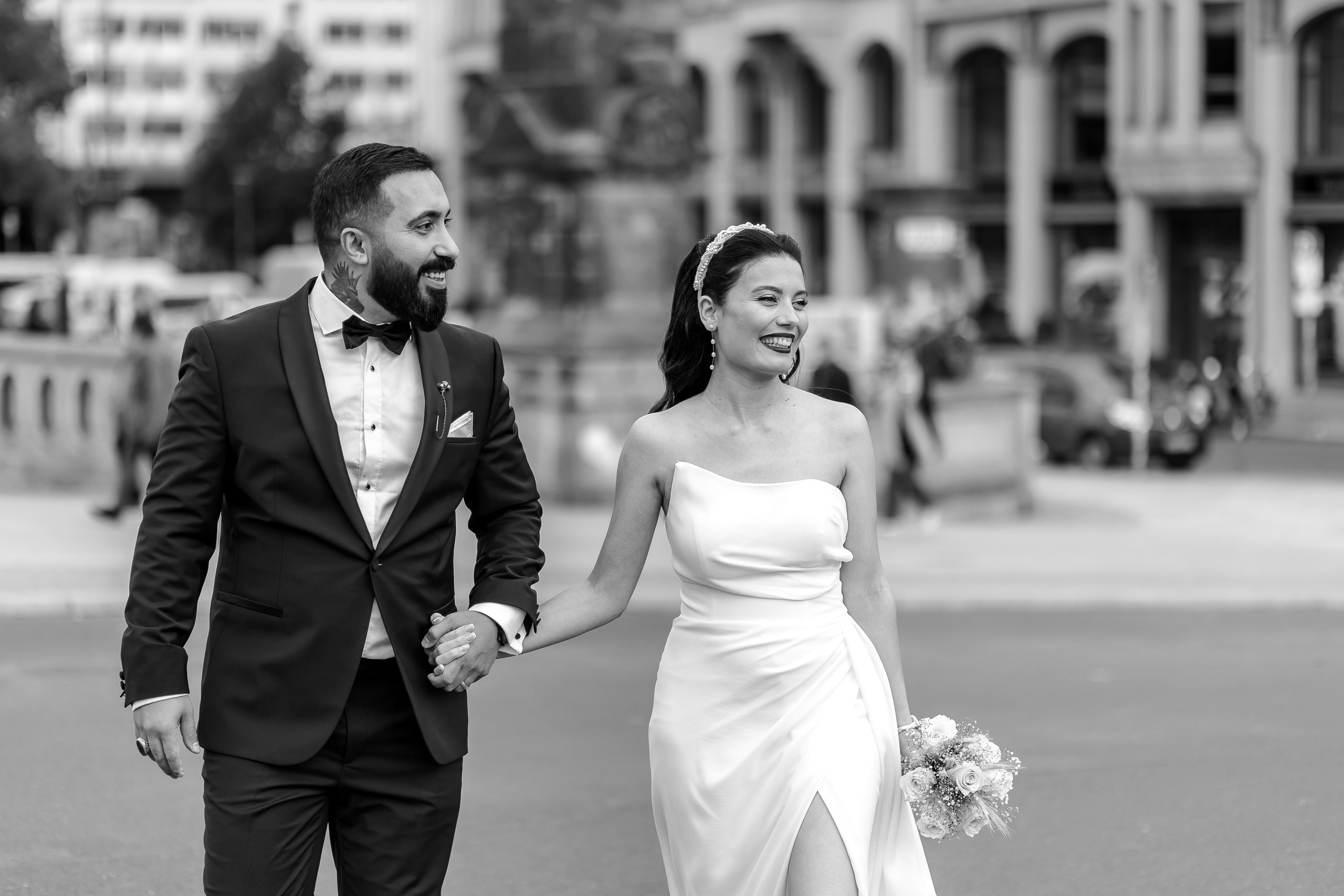 Brautpaar spaziert Hand in Hand durch Berlin – Schwarz-Weiß-Hochzeitsfoto