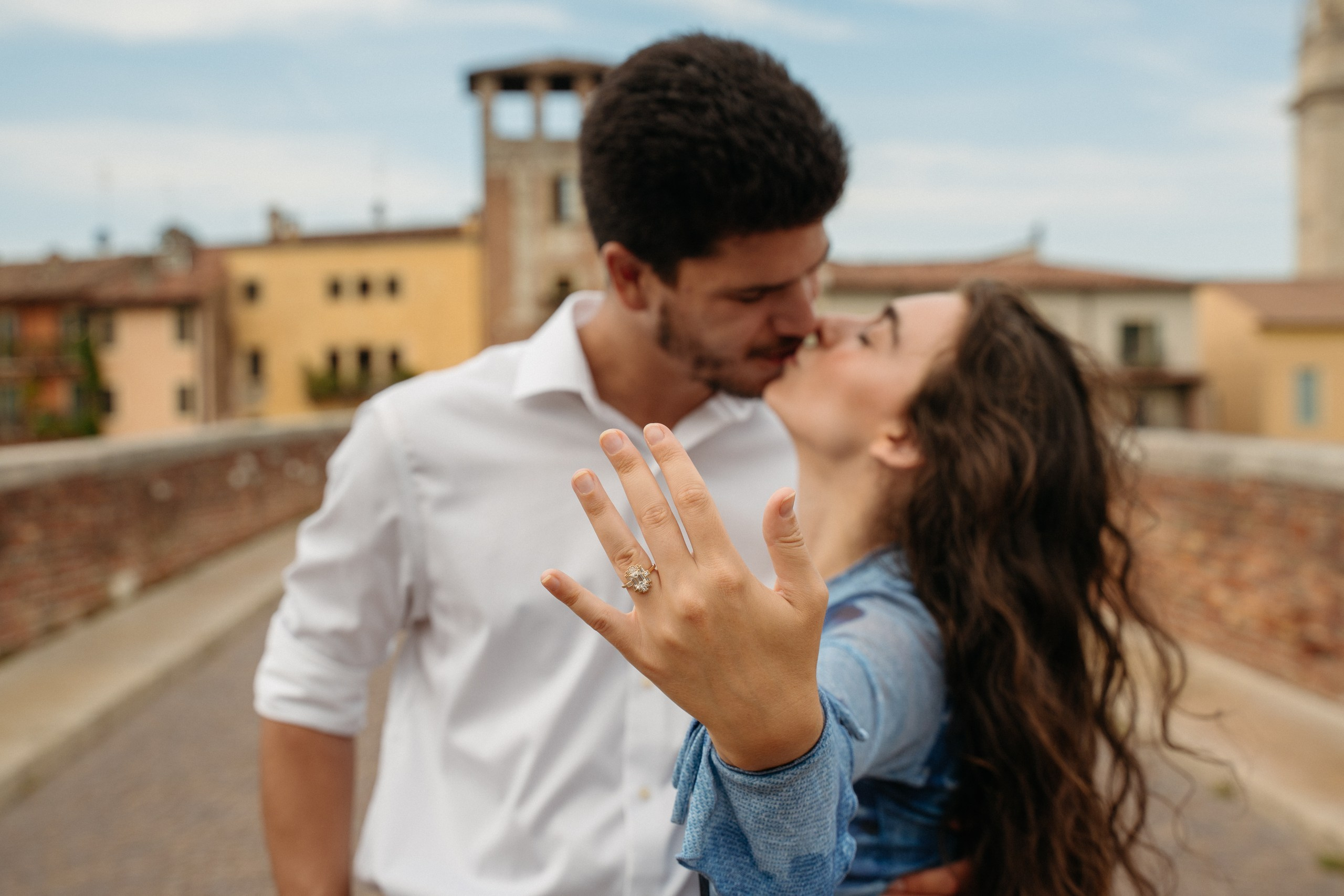 Surprise proposal on Ponte Pietra with emotional engagement photos and a love story session at Castel San Pietro above Verona, Italy.