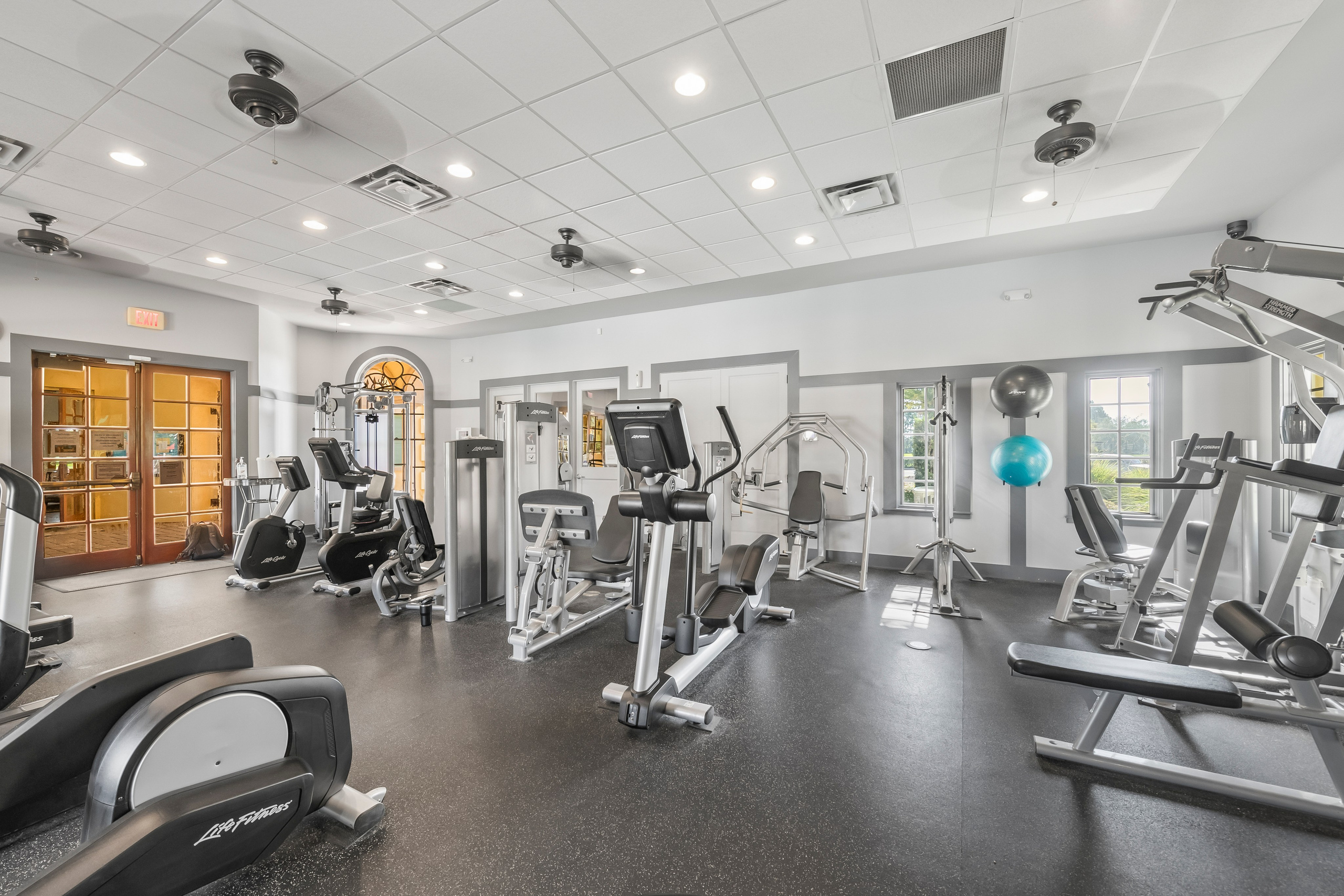 Bright gym interior with cardio and strength training equipment