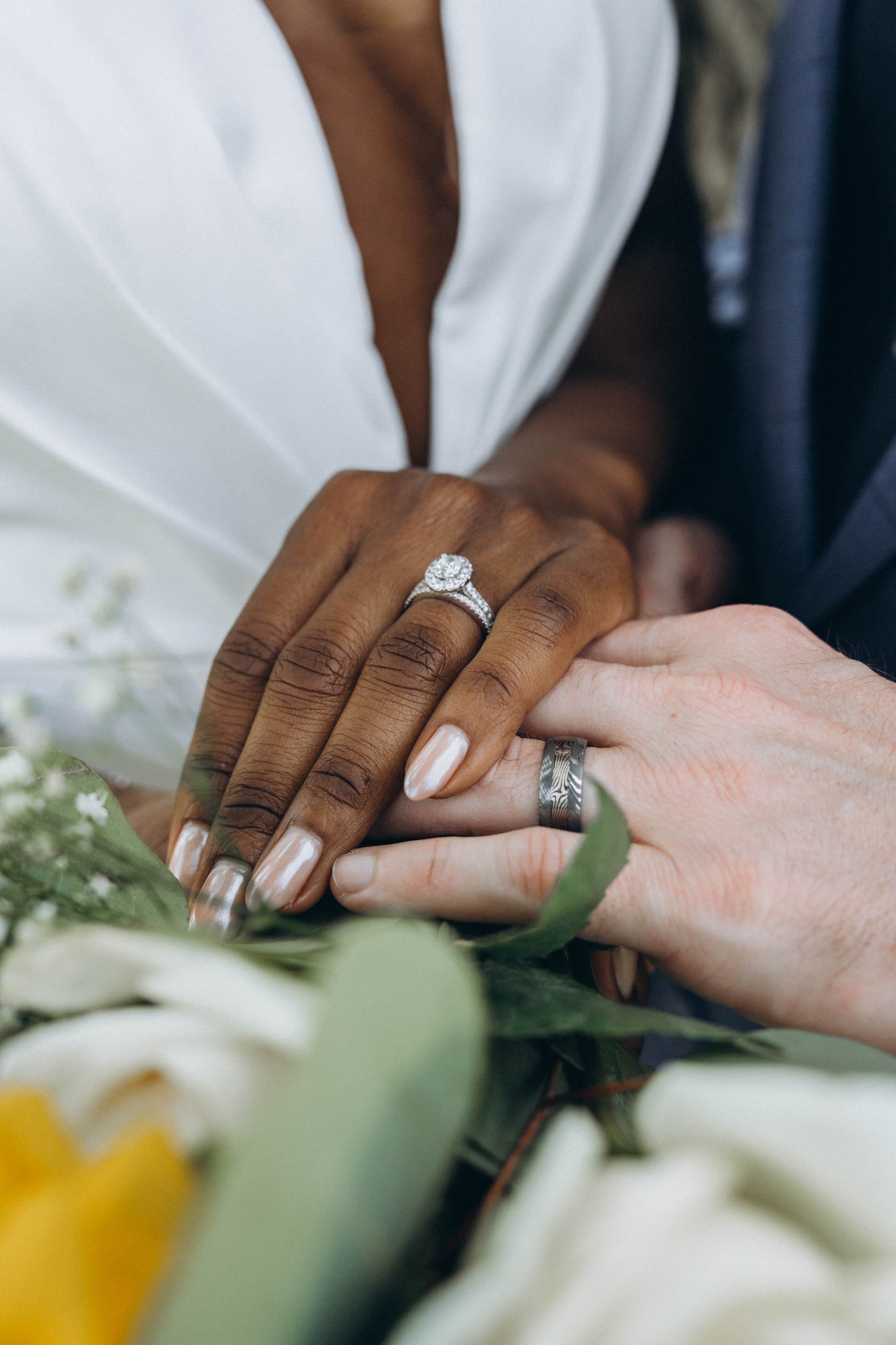 Candid ceremony photo of bride and groom holding hands at altar