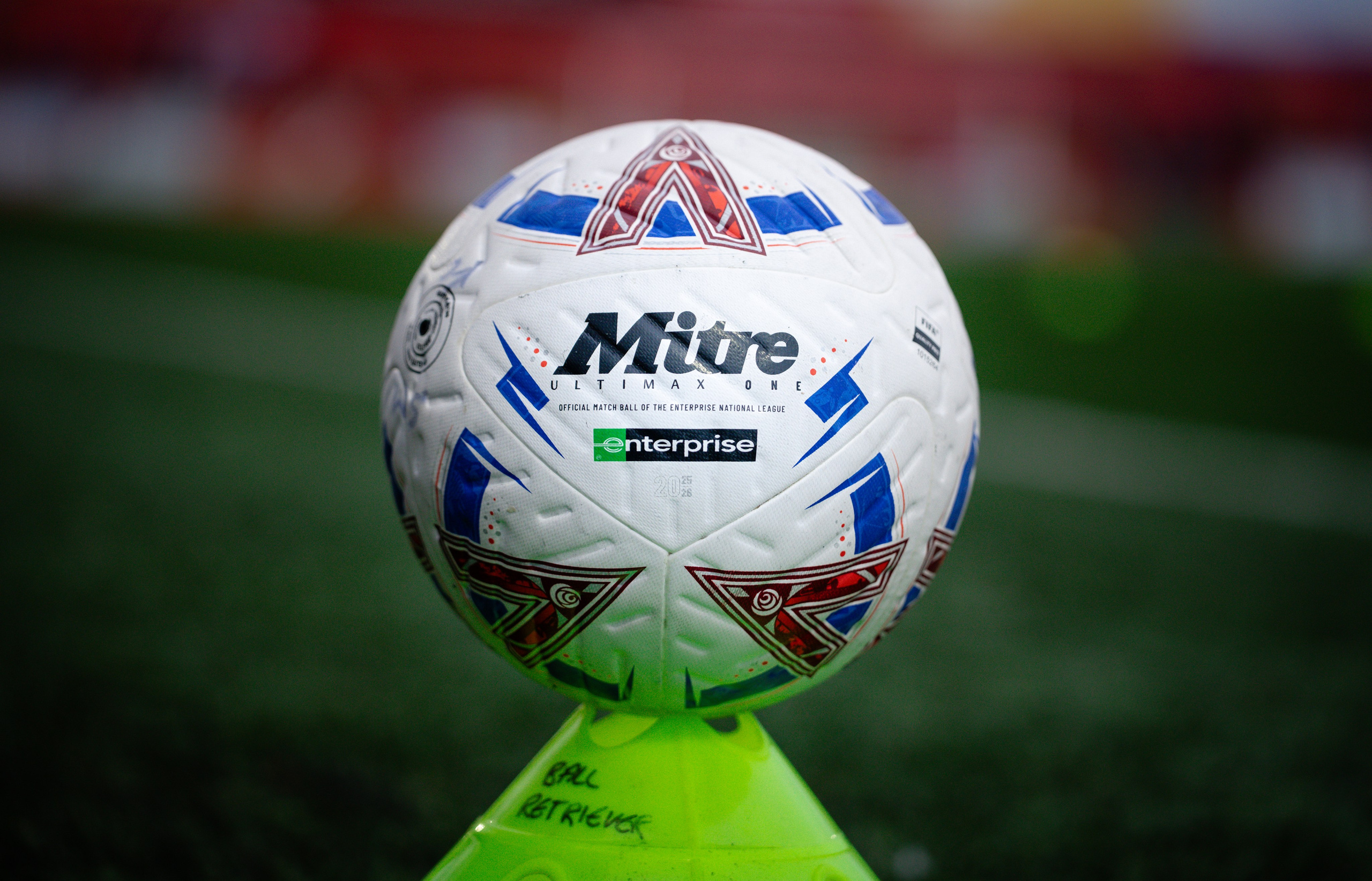 Close-up of the Enterprise National League match ball resting on a training cone before kickoff.