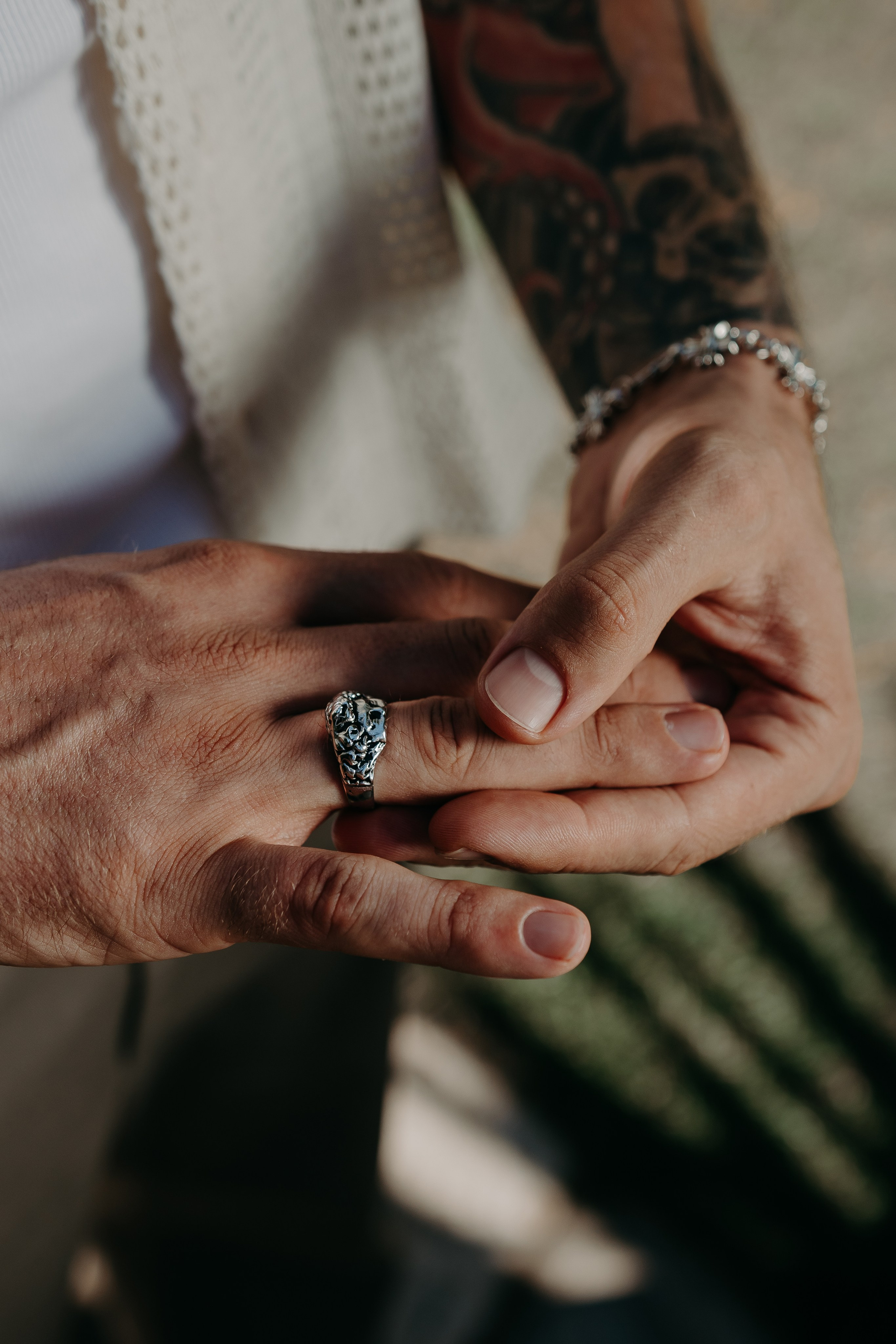 Hand adorned with a silver bracelet and ring, highlighting intricate accessory details.