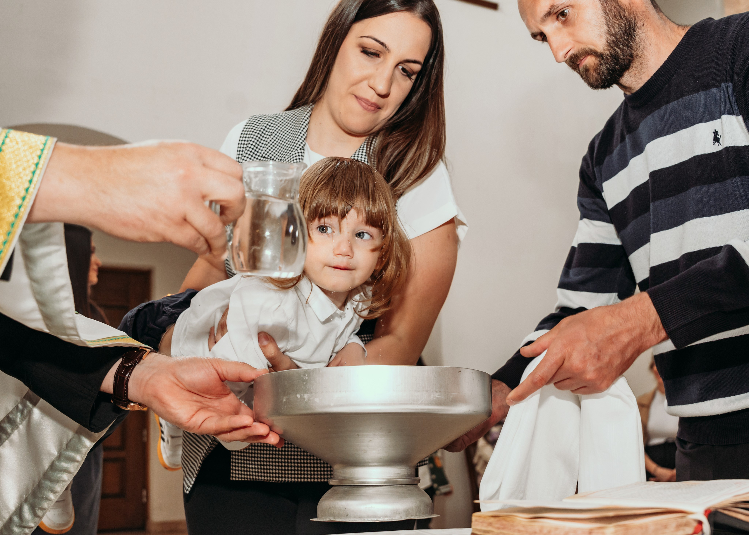 Fotografija krštenja deteta pored oltara u Beogradu