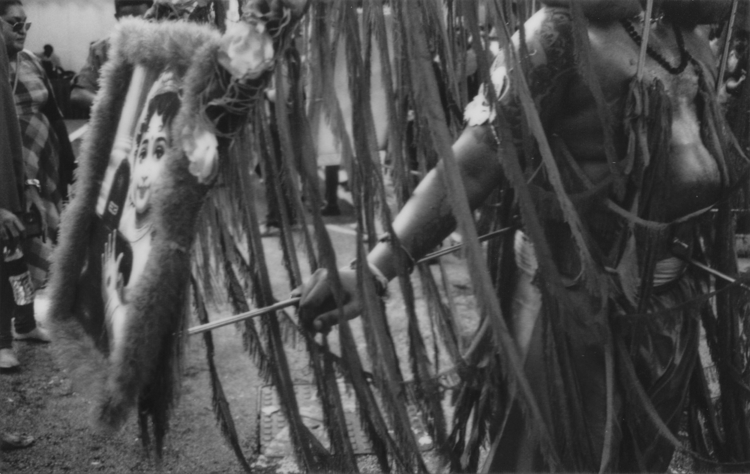 A striking black-and-white photograph capturing a Thaipusam devotee holding a ceremonial spear, framed by intricate garlands and vibrant textures in Singapore. The close composition emphasizes the physical and spiritual endurance of the ritual, bringing depth and authenticity to the moment. This image underscores the photographer’s talent in event reportage and cultural photojournalism, offering clients exceptional coverage of meaningful events and celebrations.