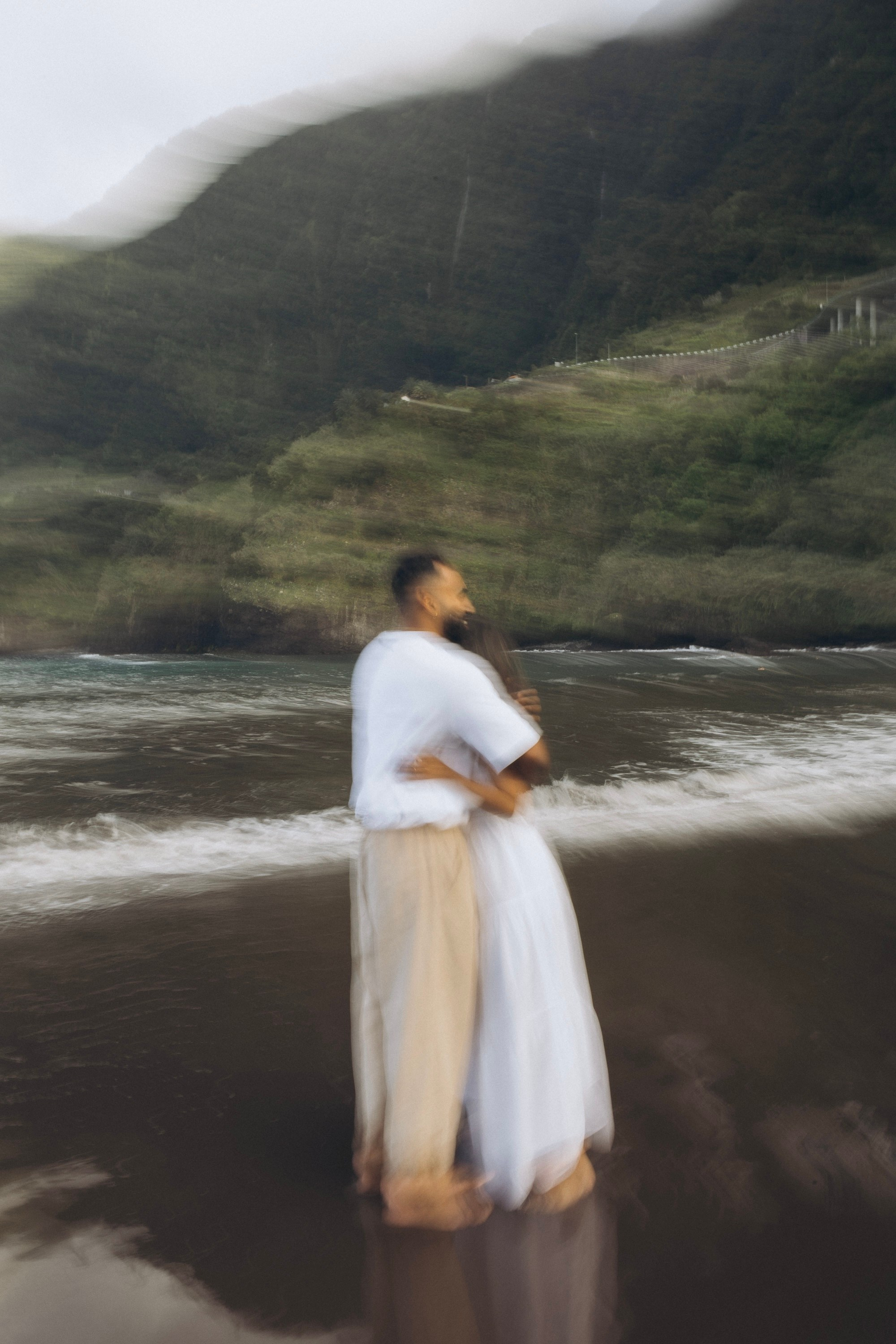 Romantic proposal on Seixal Beach, Madeira — black sand and ocean waves.