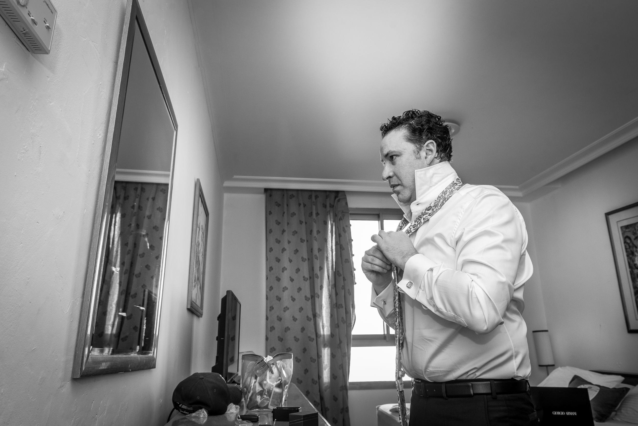 Groom Michael adjusting his wedding tie at the Leonardo Hotel in Haifa, Israel