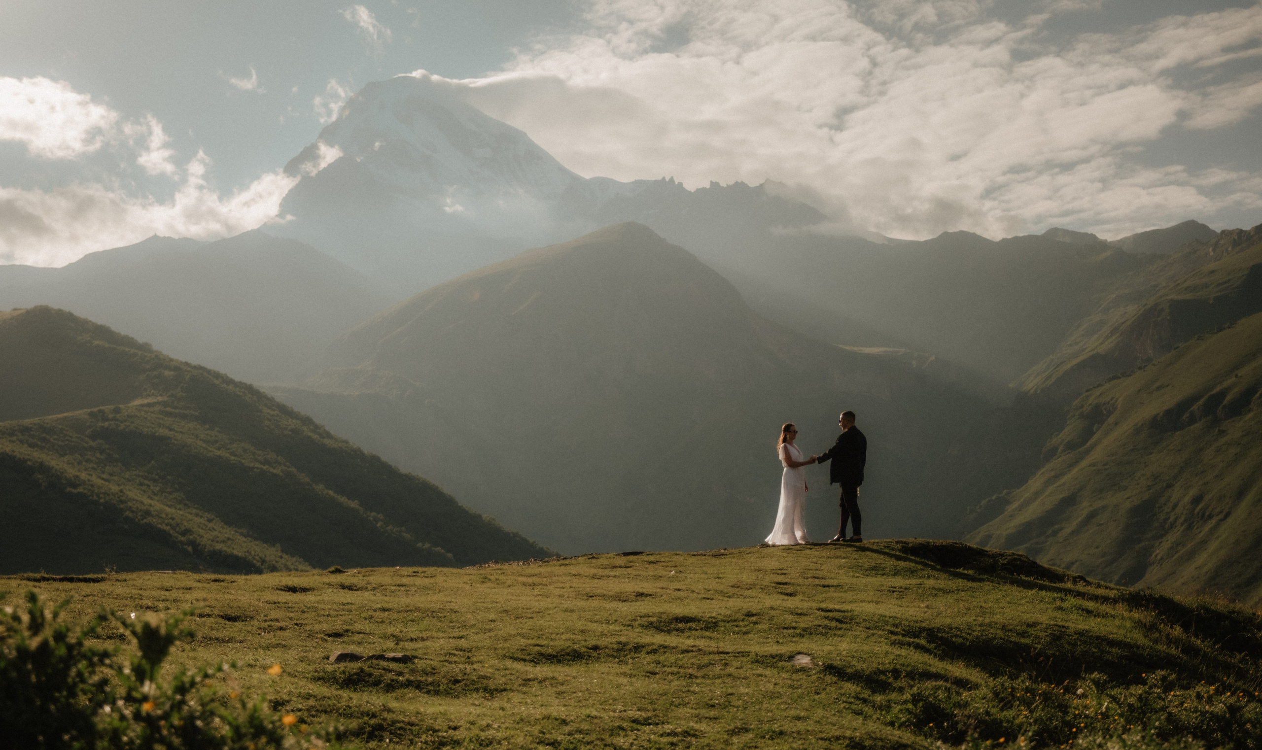 Photo shot of couple hiking in the hills above Stepantsminda
