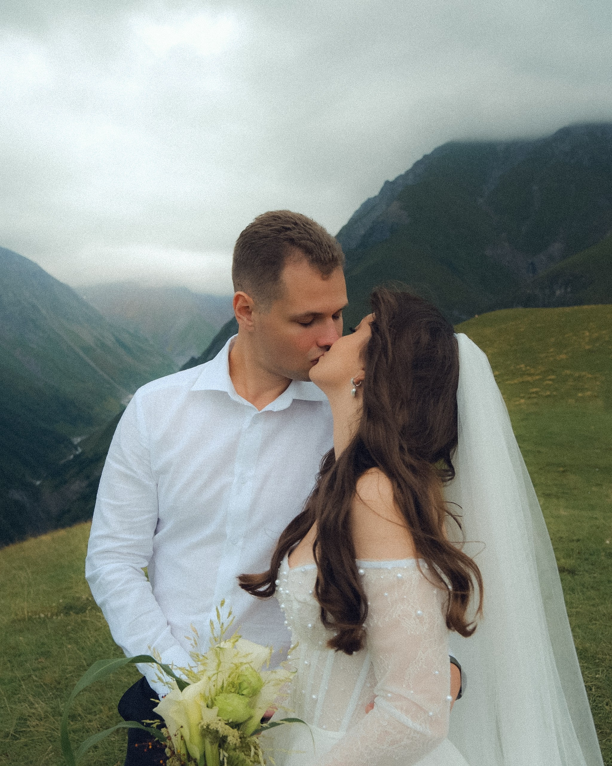 Couple kissing in cloudy mountain weather