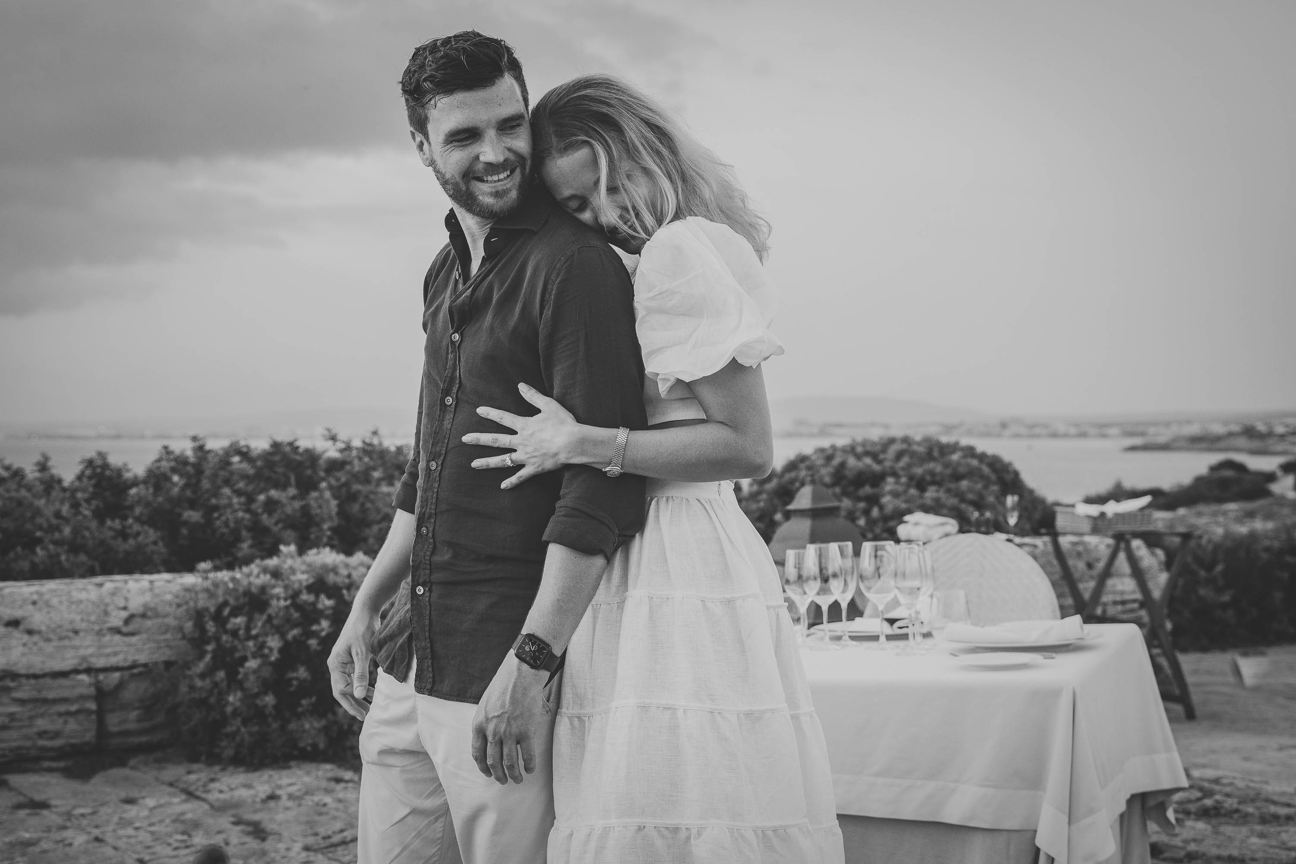 Engagement in Mallorca, bride hugs groom, at Cap Rocat Wedding Hotel