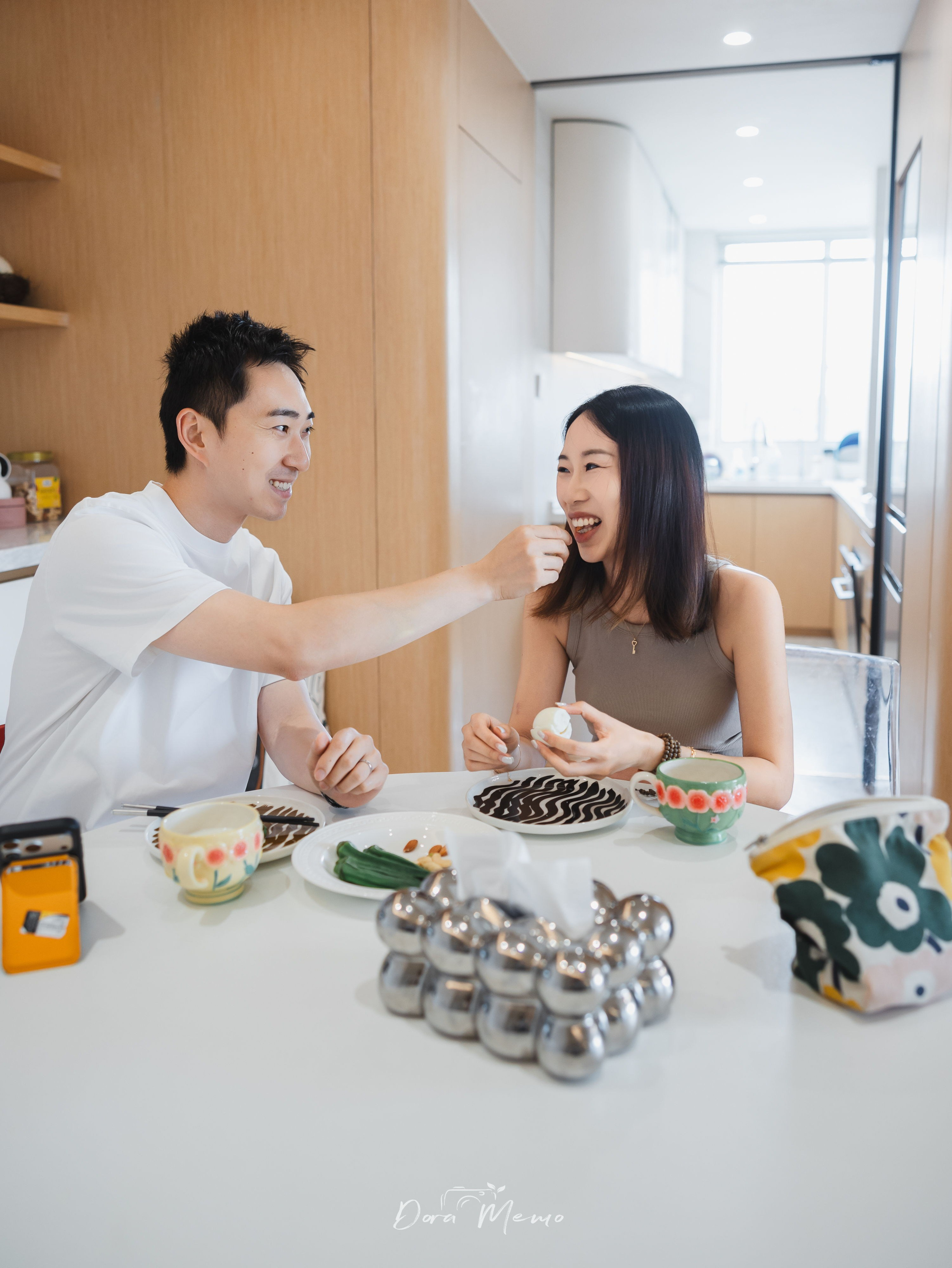 A couple laughing together at the dining table during a relaxed Shanghai lifestyle photography session.