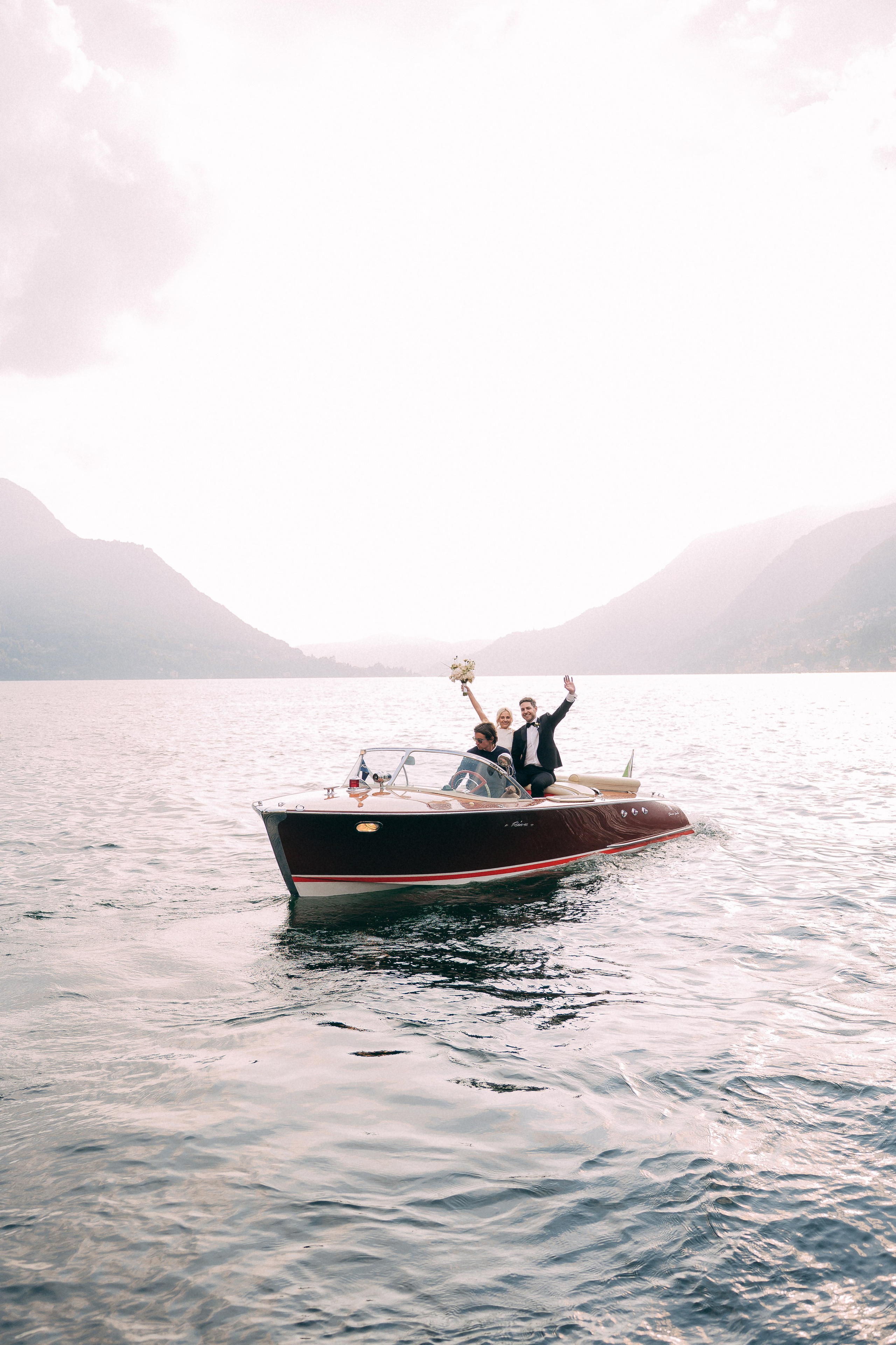 Classic boat sailing on Lake Como near Villa Lario, Italy