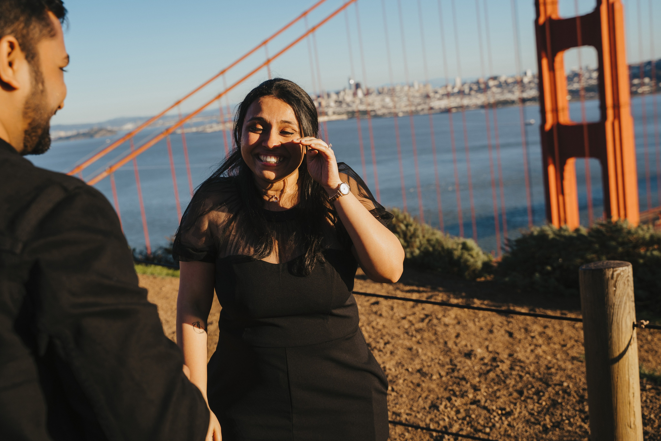 Proposal.  Overlooking the golden San Franisco Bridge sunset with a couple. Photographer Video. 