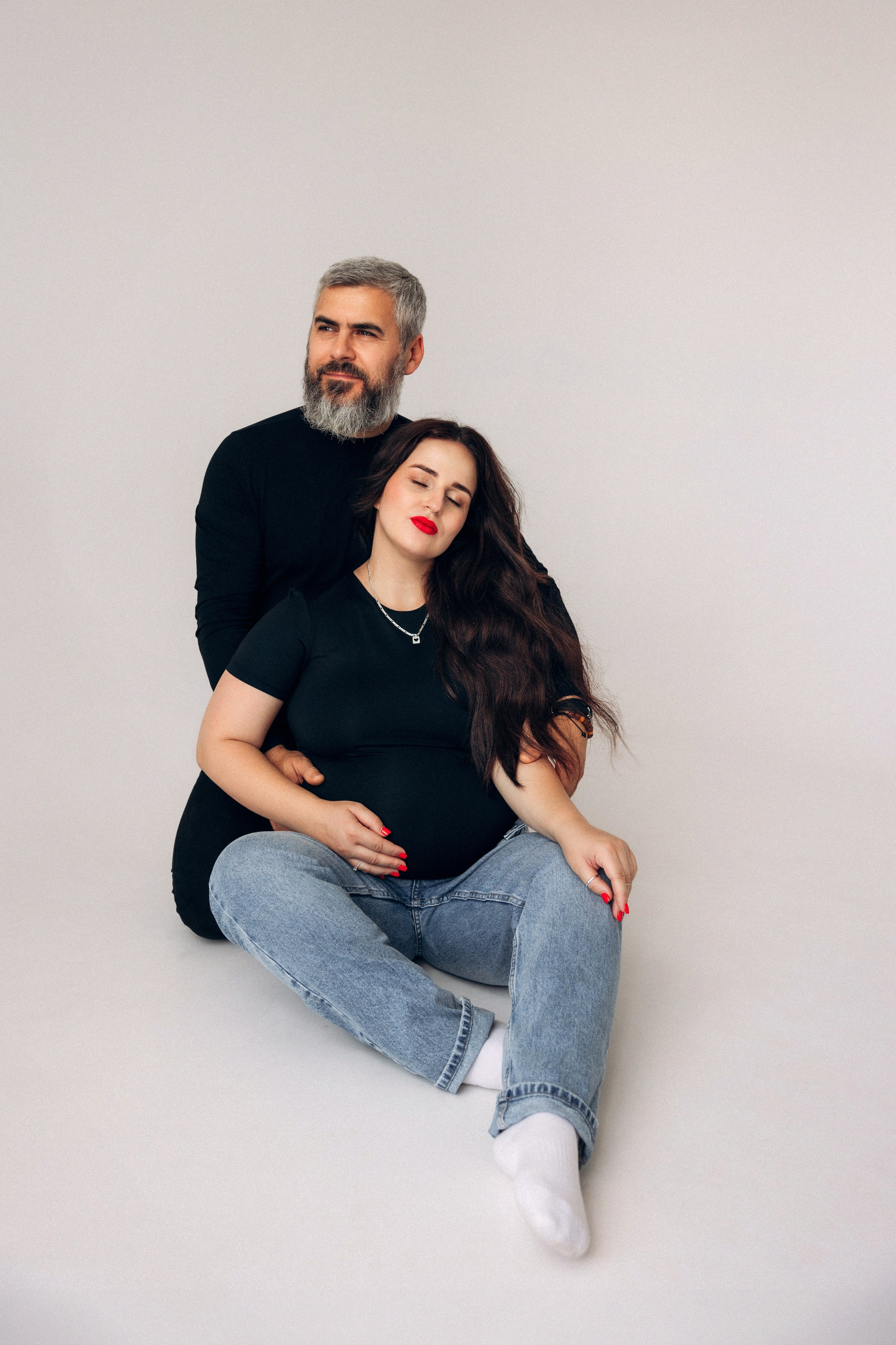 Stylowa przyszła mama – minimalistyczna stylizacja i świadoma poza w jasnej przestrzeni.