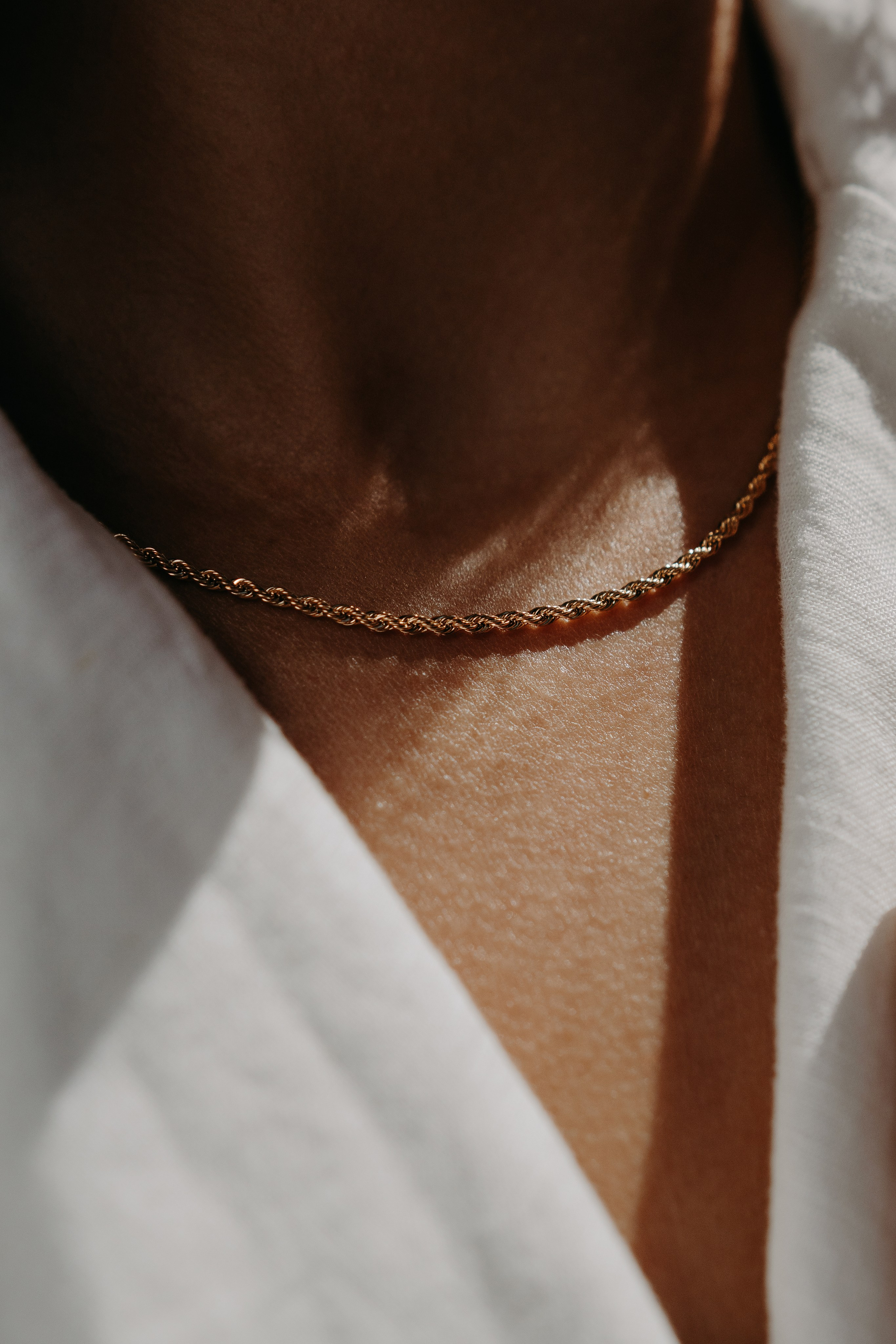 Delicate gold necklace and bracelet combination on a model, emphasizing minimalist fashion.