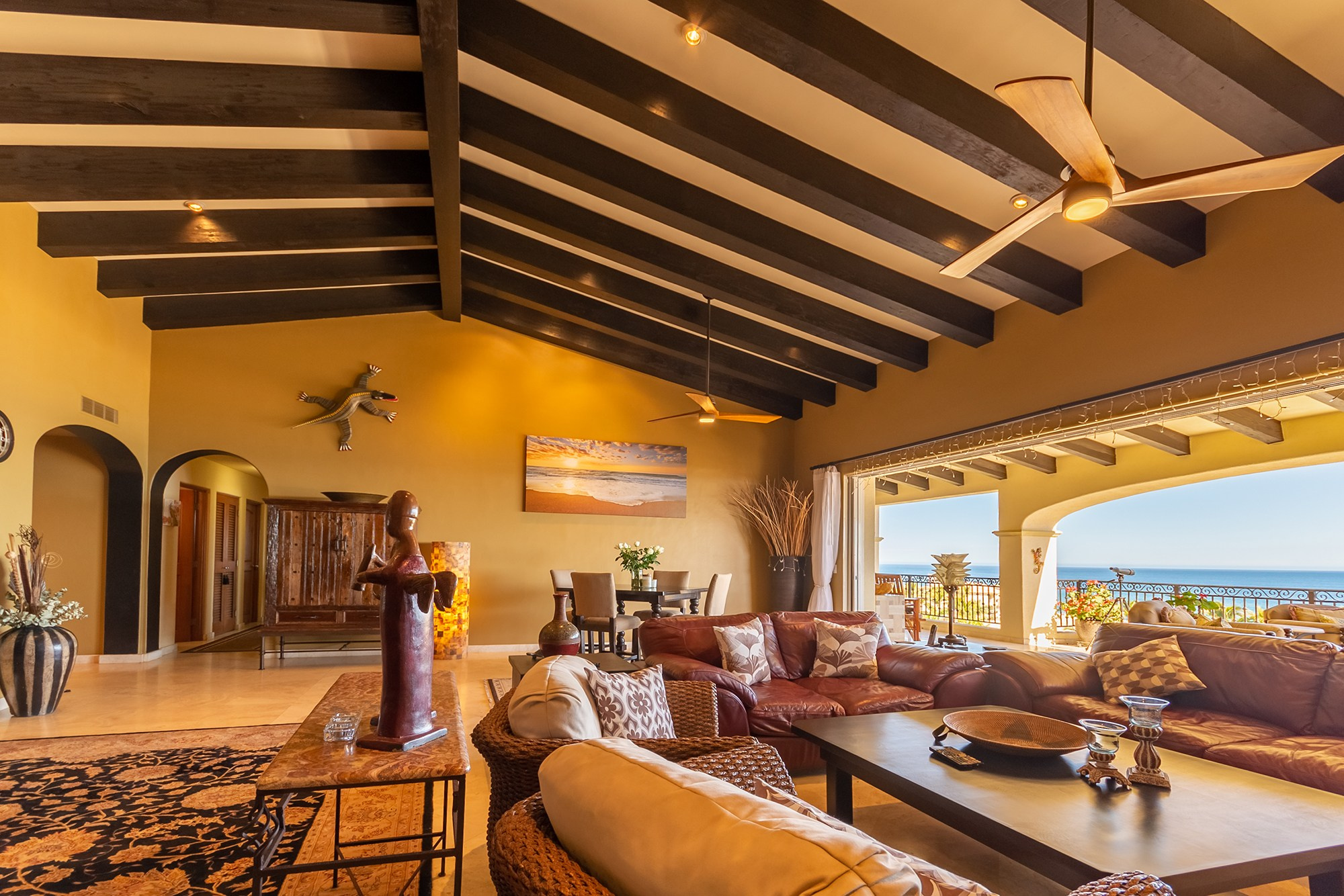 Spacious living room in Baja California Sur – vaulted wooden ceiling and ocean view balcony, luxury real estate photography