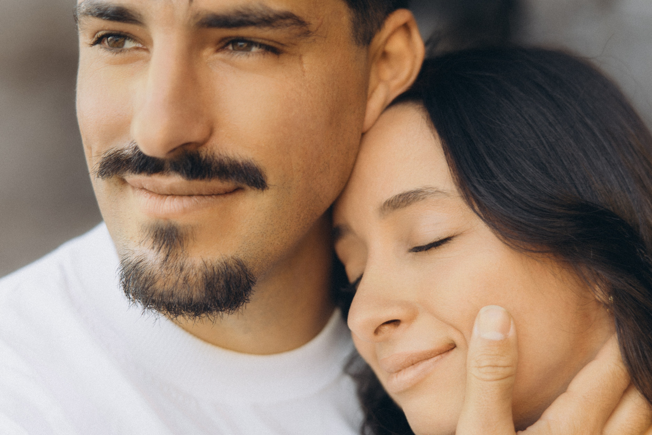 Couple sharing a romantic moment during sunset on Madeira Island, with the ocean and cliffs in the background