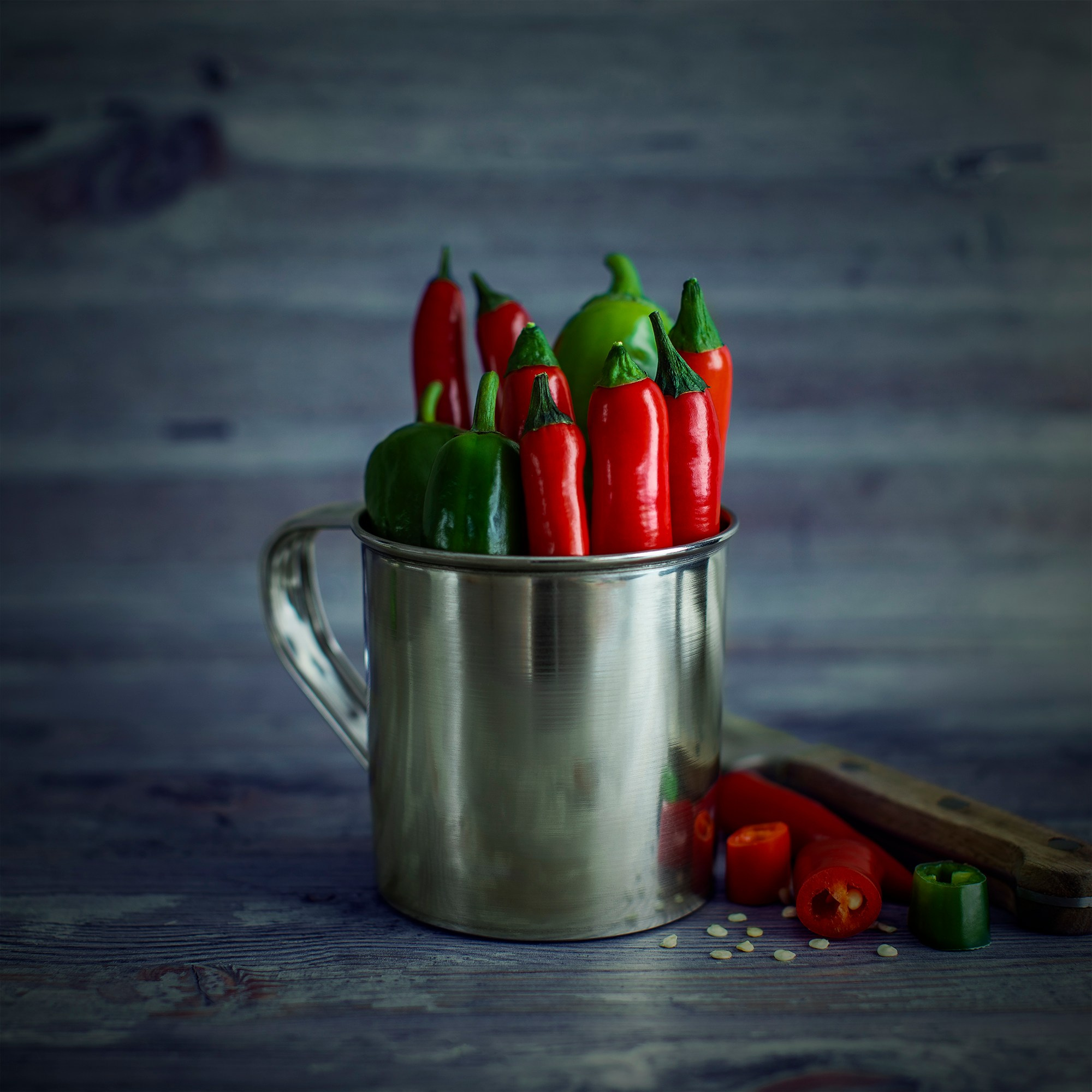 Photographer Roman Djuzev - Chili pepper in a metal mug on a wooden table.