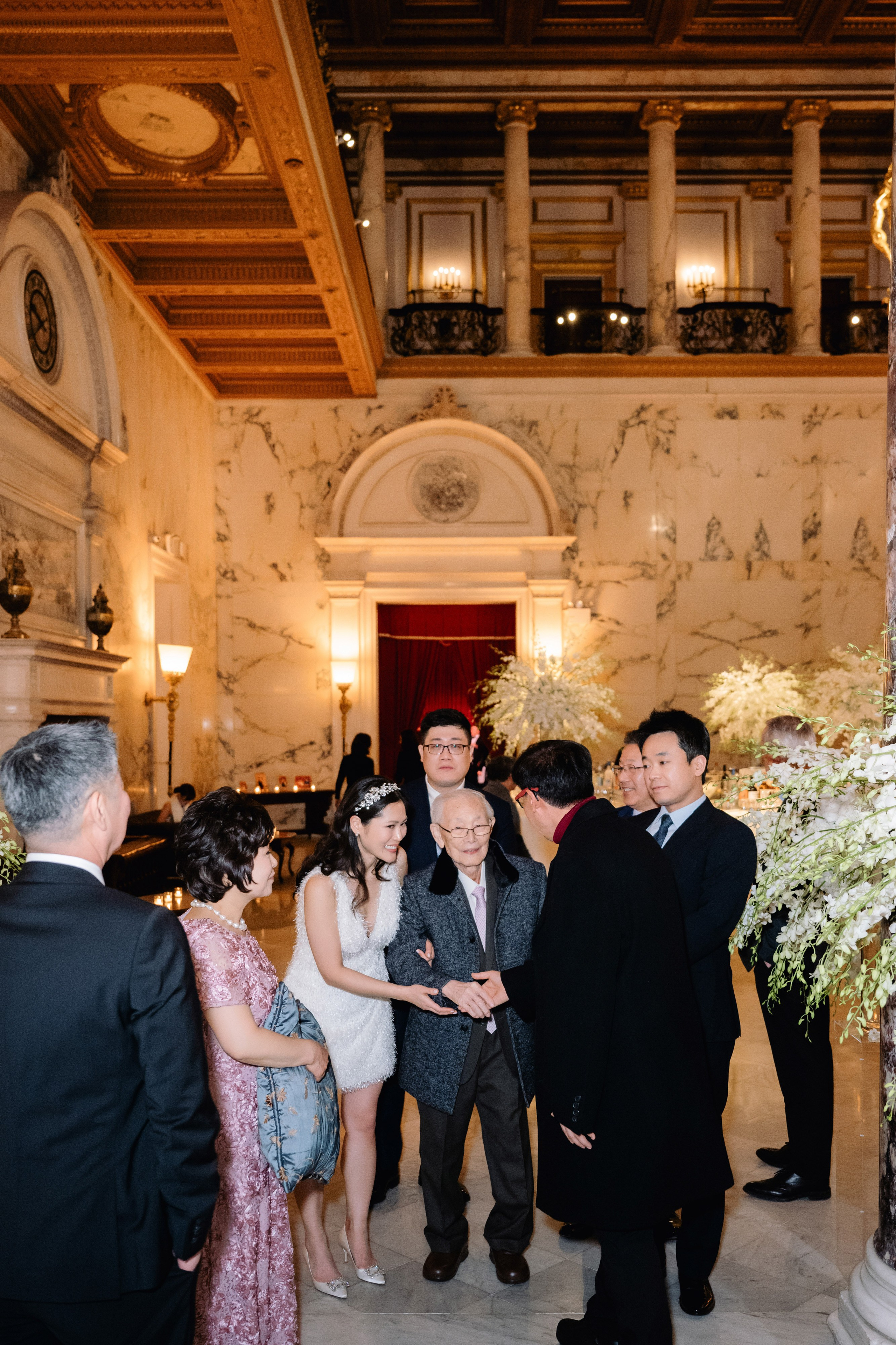 a group of people standing around a wedding cake