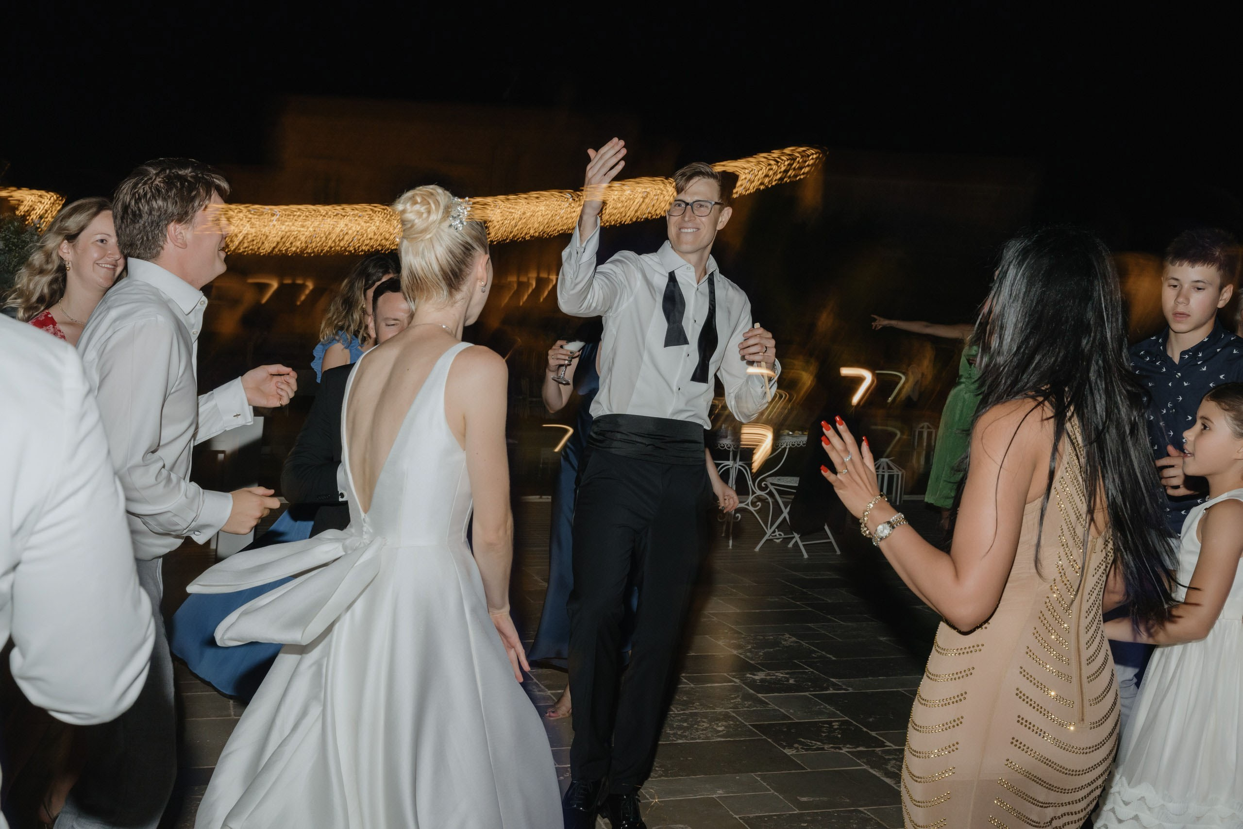 Crowd dancing under night sky at Italian villa wedding, vibrant destination wedding in Puglia Italy