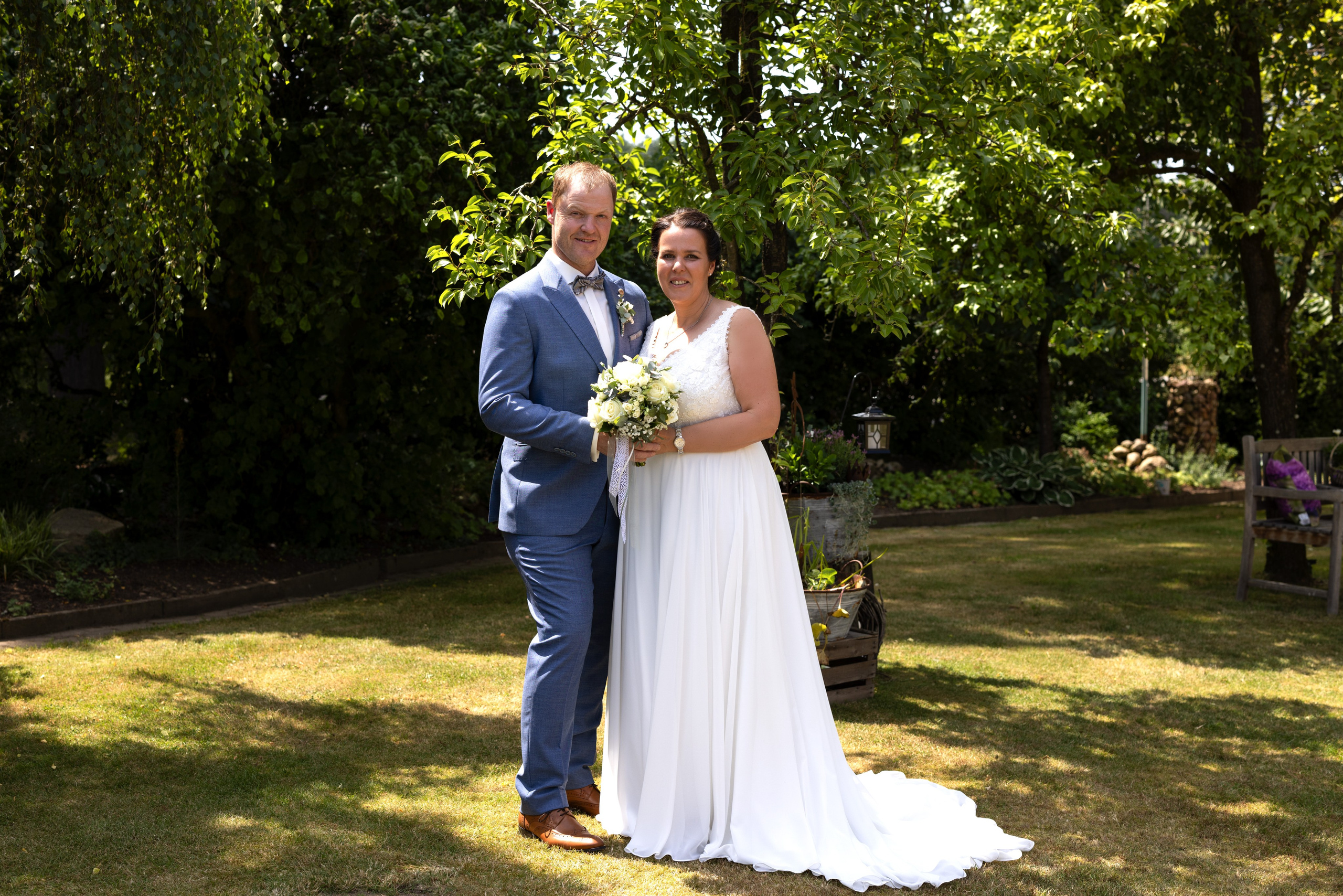 „Hochzeitsfotoshooting im großen Garten des Brautpaares in Bippen, mit der Familie und Gruppenbildern.