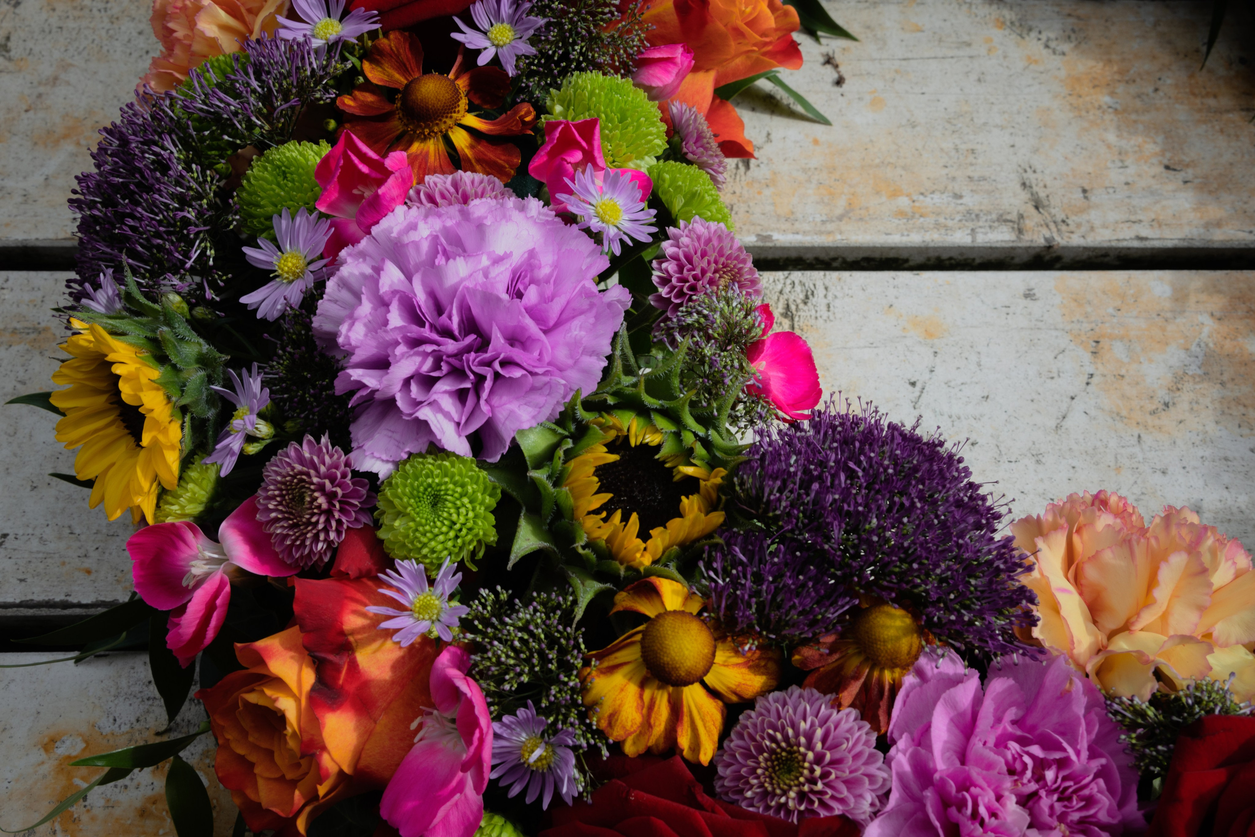 En smukt udført krans med tætsiddende blomster.Denne krans imponerer med sin multikolorerede sammensætning af både store og små blomster.