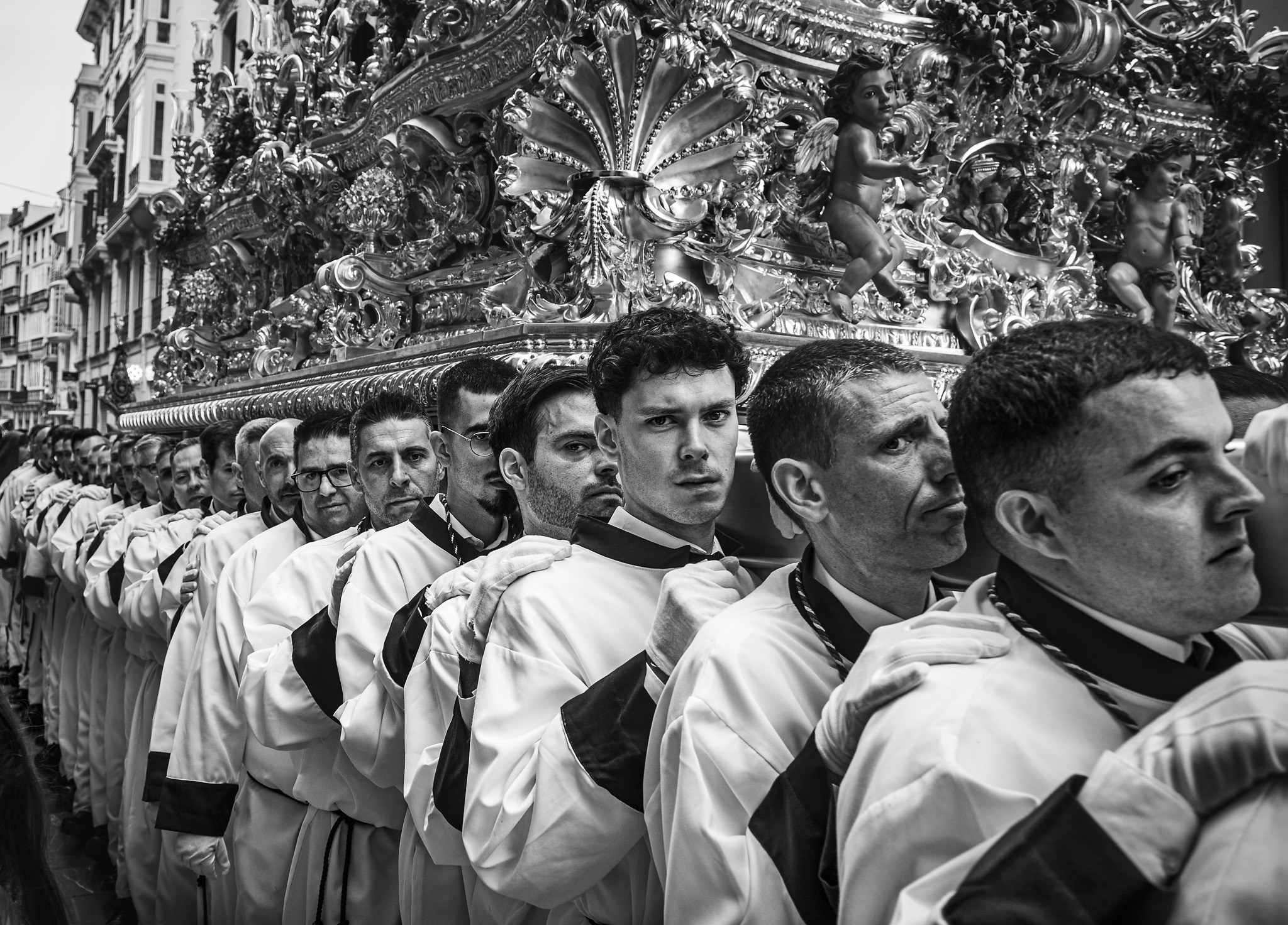 Costaleros walking shoulder to shoulder during Holy Week procession in Spain