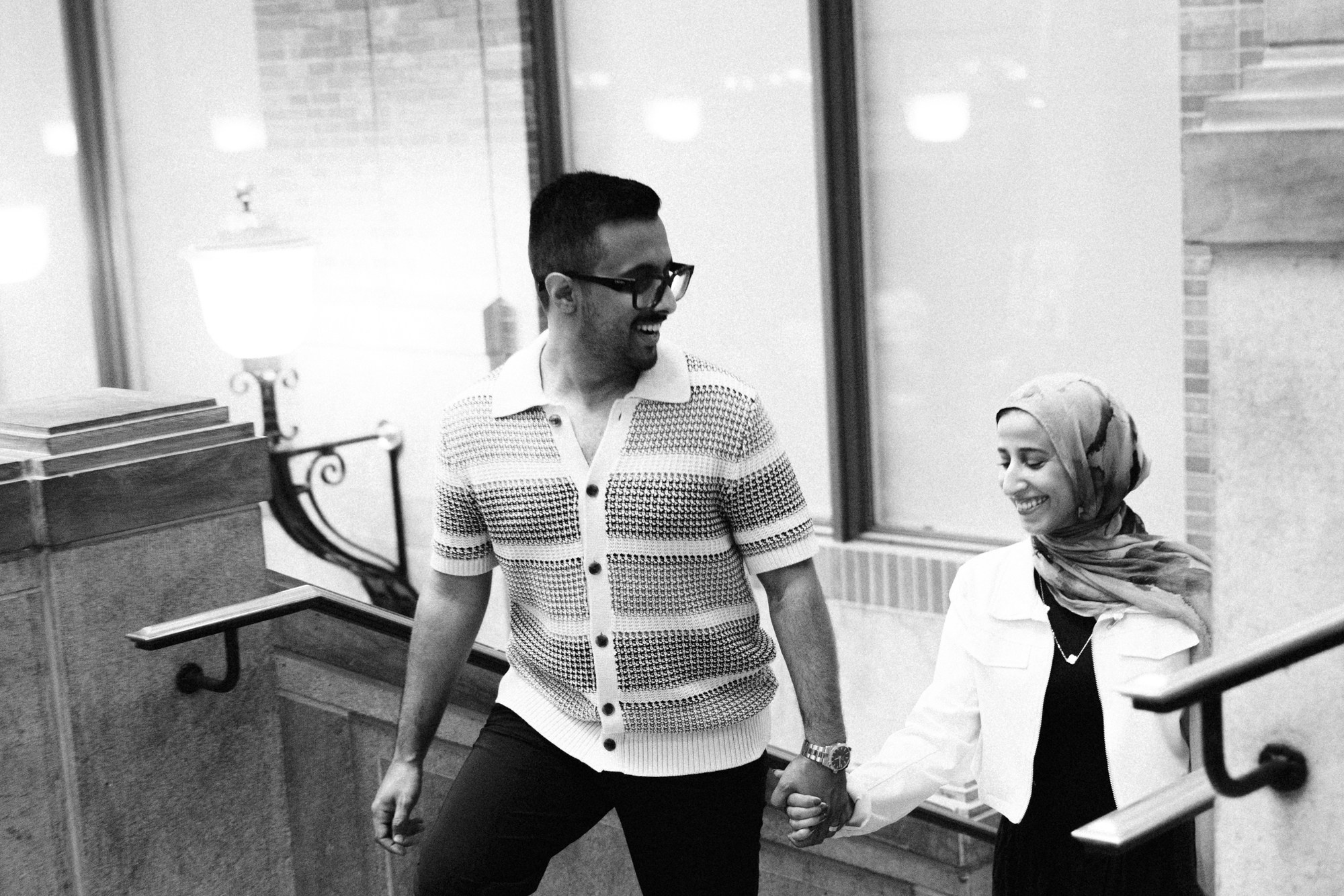 Couple holding hands on staircase in Montreal building