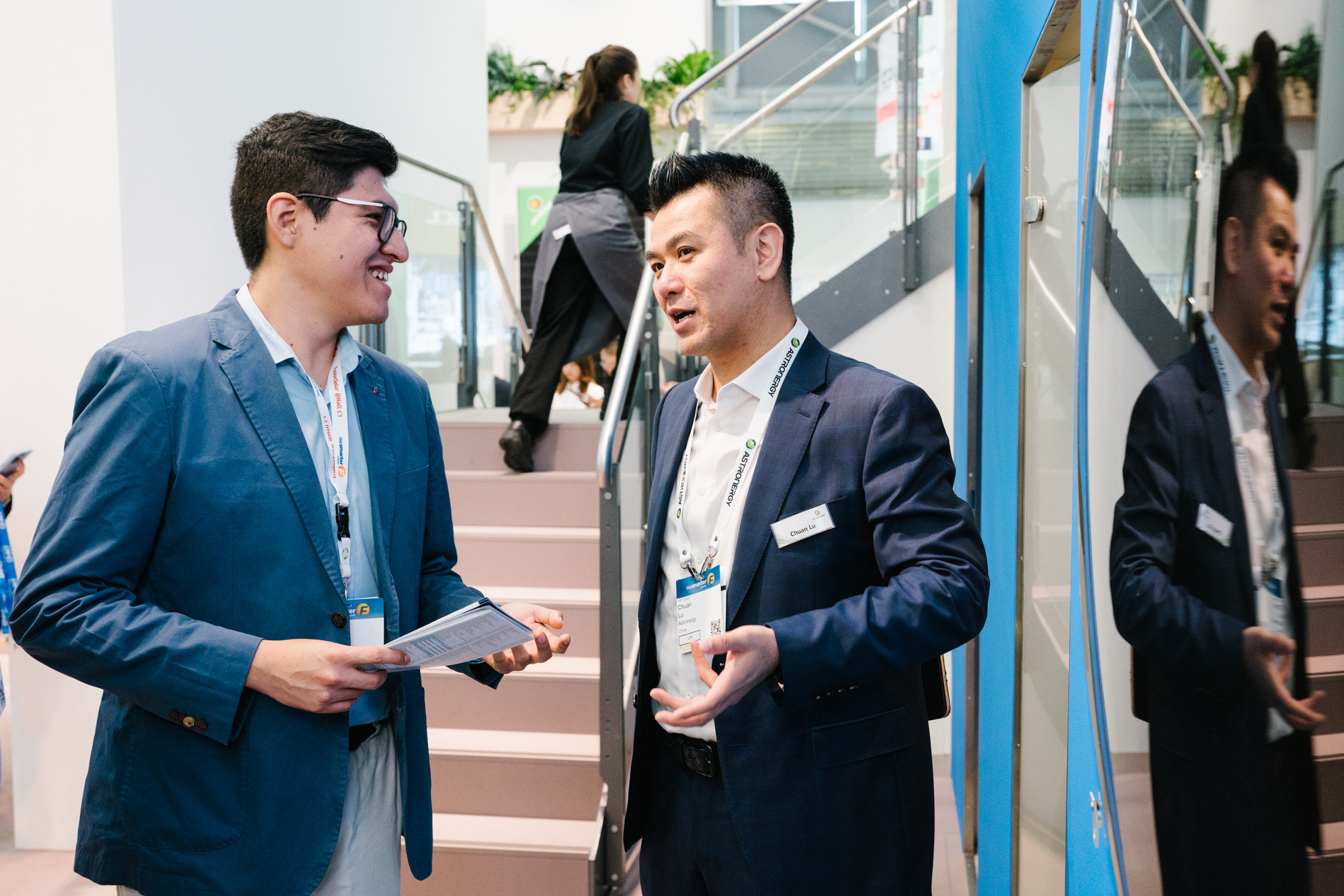 Two business representatives reviewing notes at an expo booth