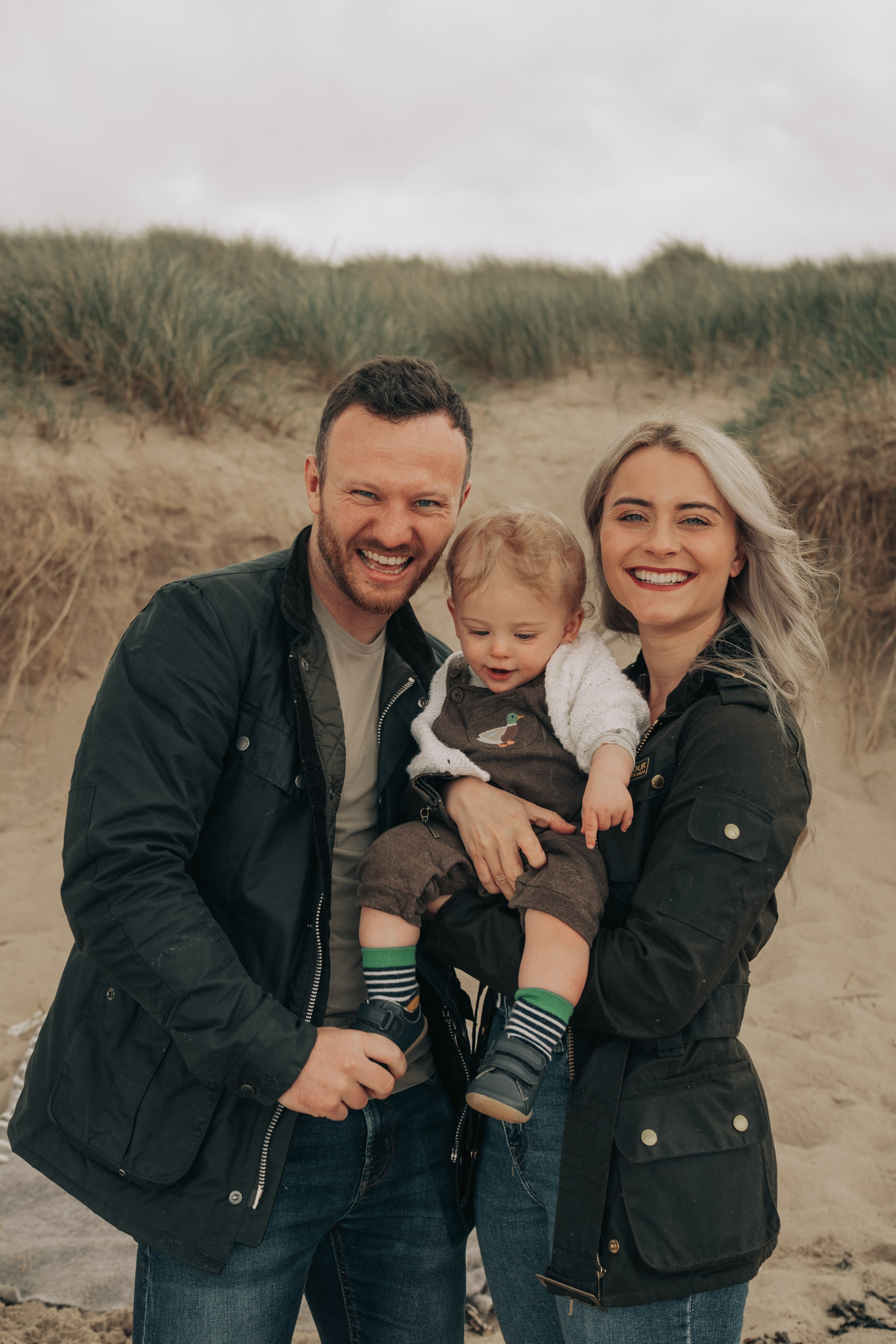 Parents cuddling their children during a relaxed family shoot on Whitley Bay beach