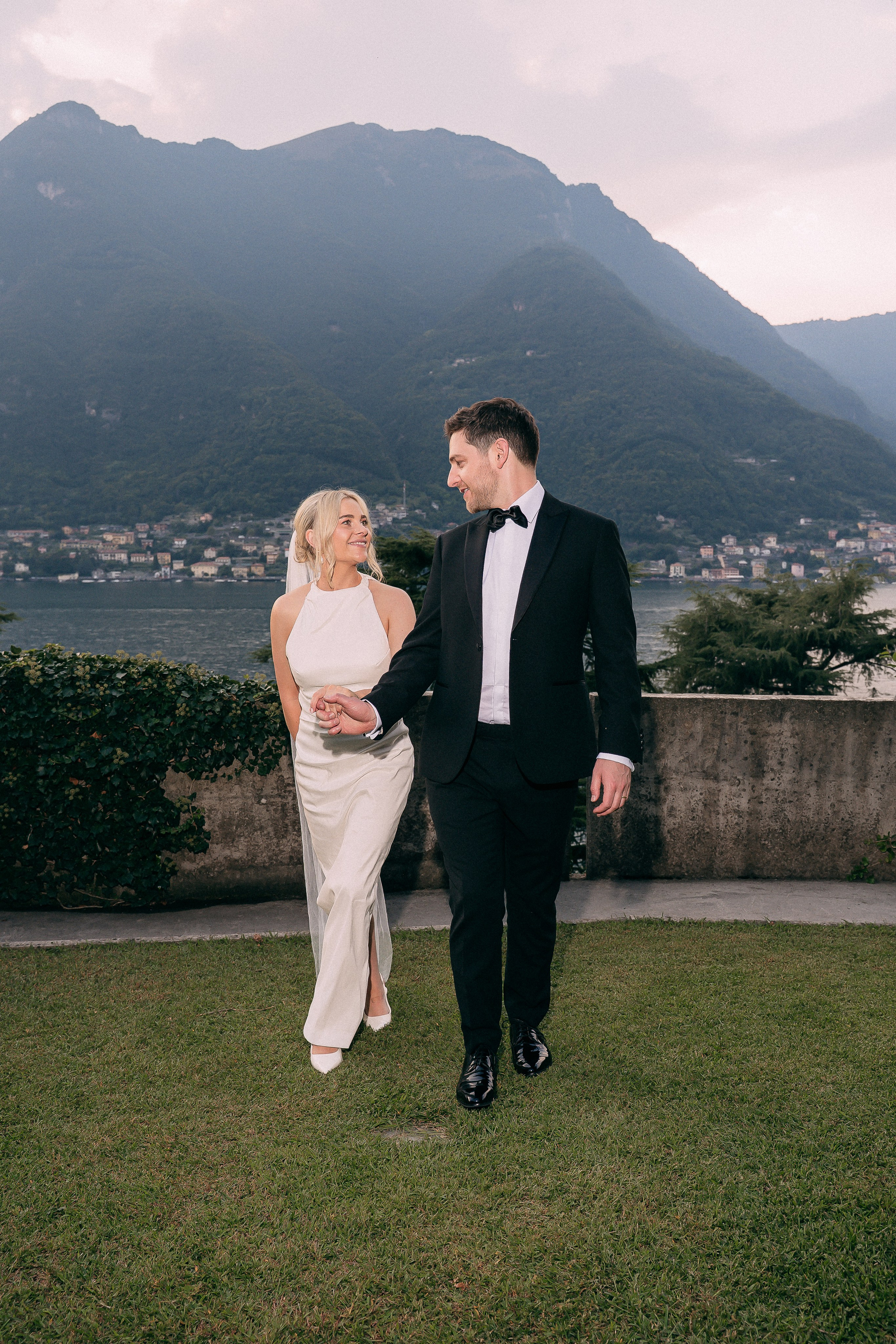 Bride and groom walking hand in hand at Villa Lario, Lake Como, Italy