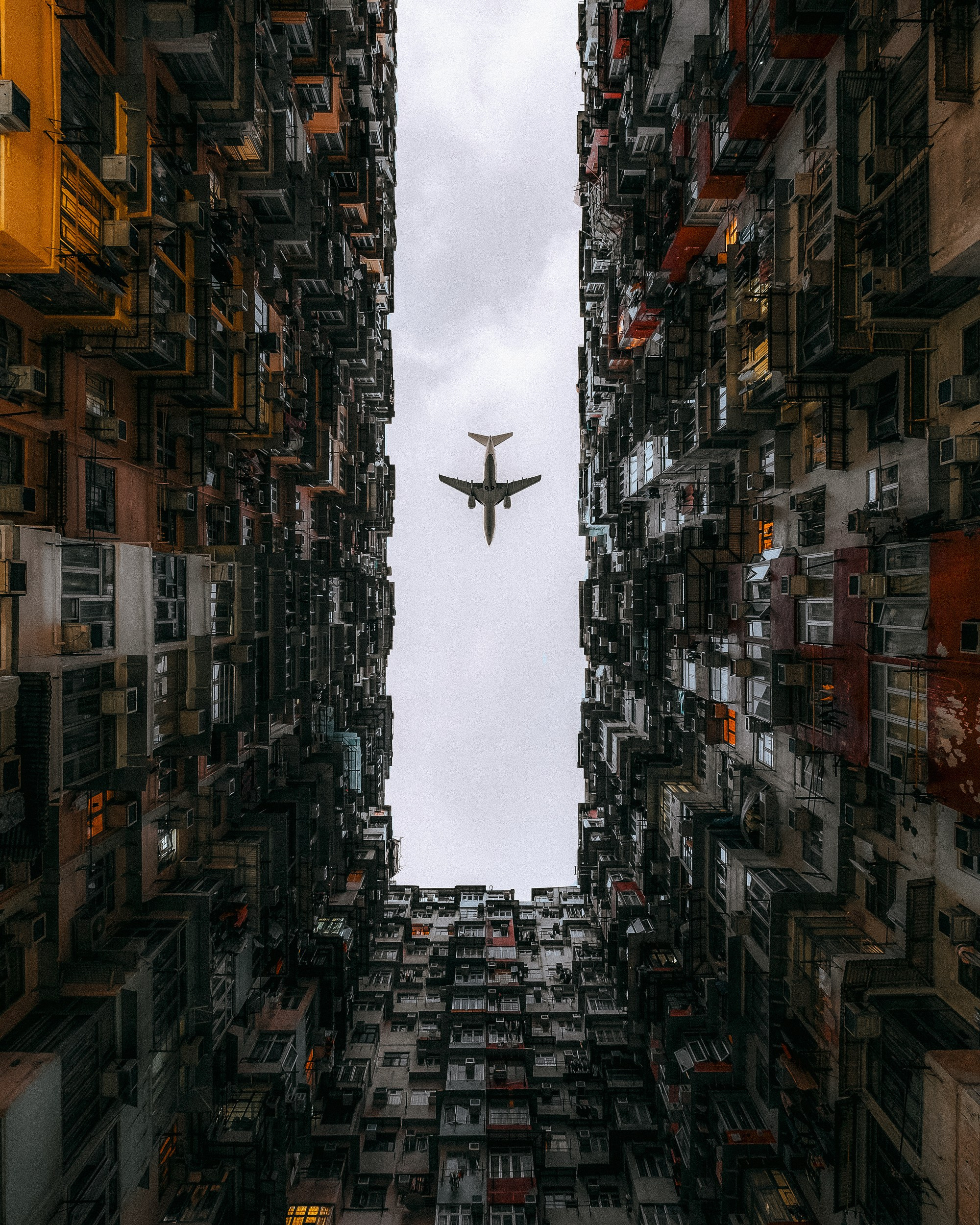 An airplane flying over a dense building in Hong Kong 