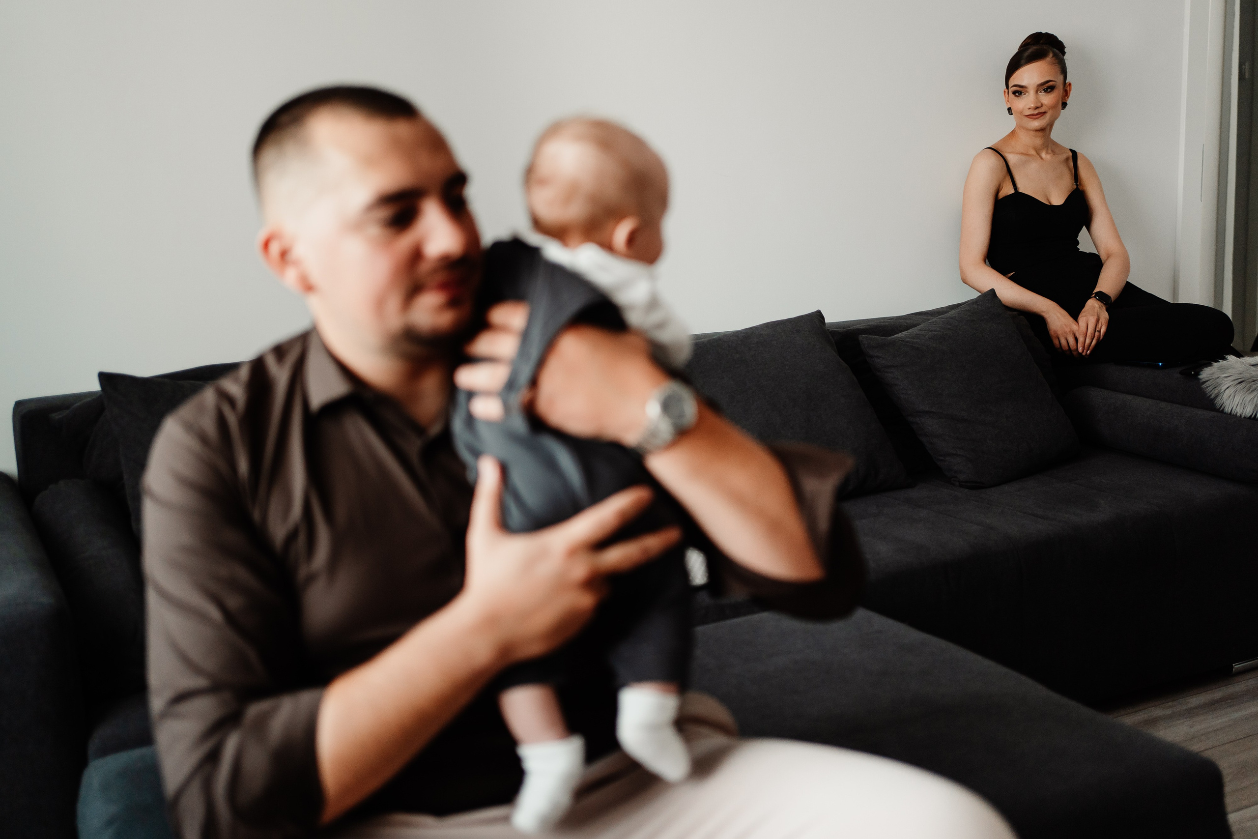 Instantaneu plin de tandrețe dintre părinți și bebeluș în ziua botezului, realizat în Craiova. Fotografie profesională de botez, capturând emoțiile autentice ale familiei într-un decor luminos și cald