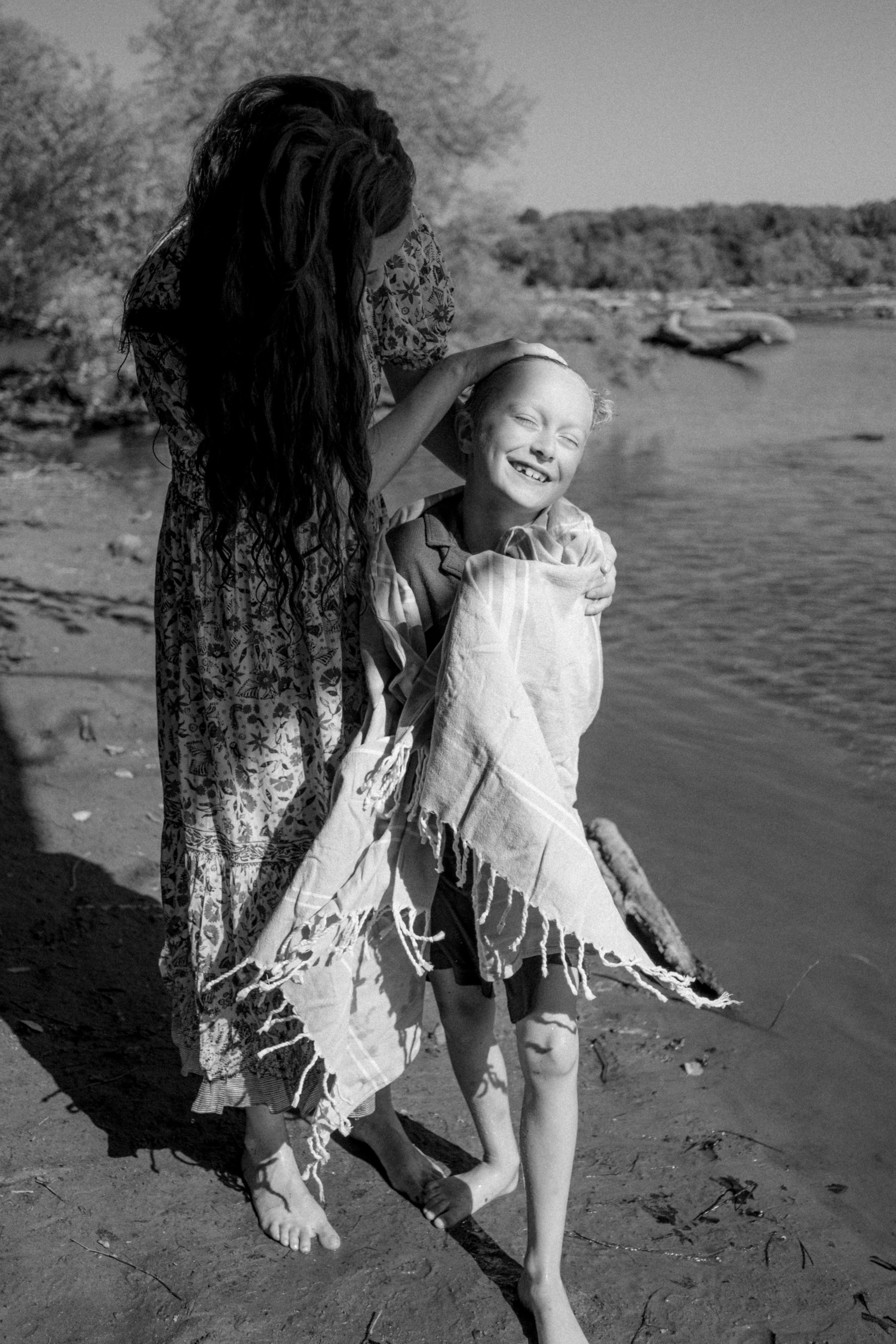 Documentary family photographer capturing candid, unposed moments of kids splashing in the James River water