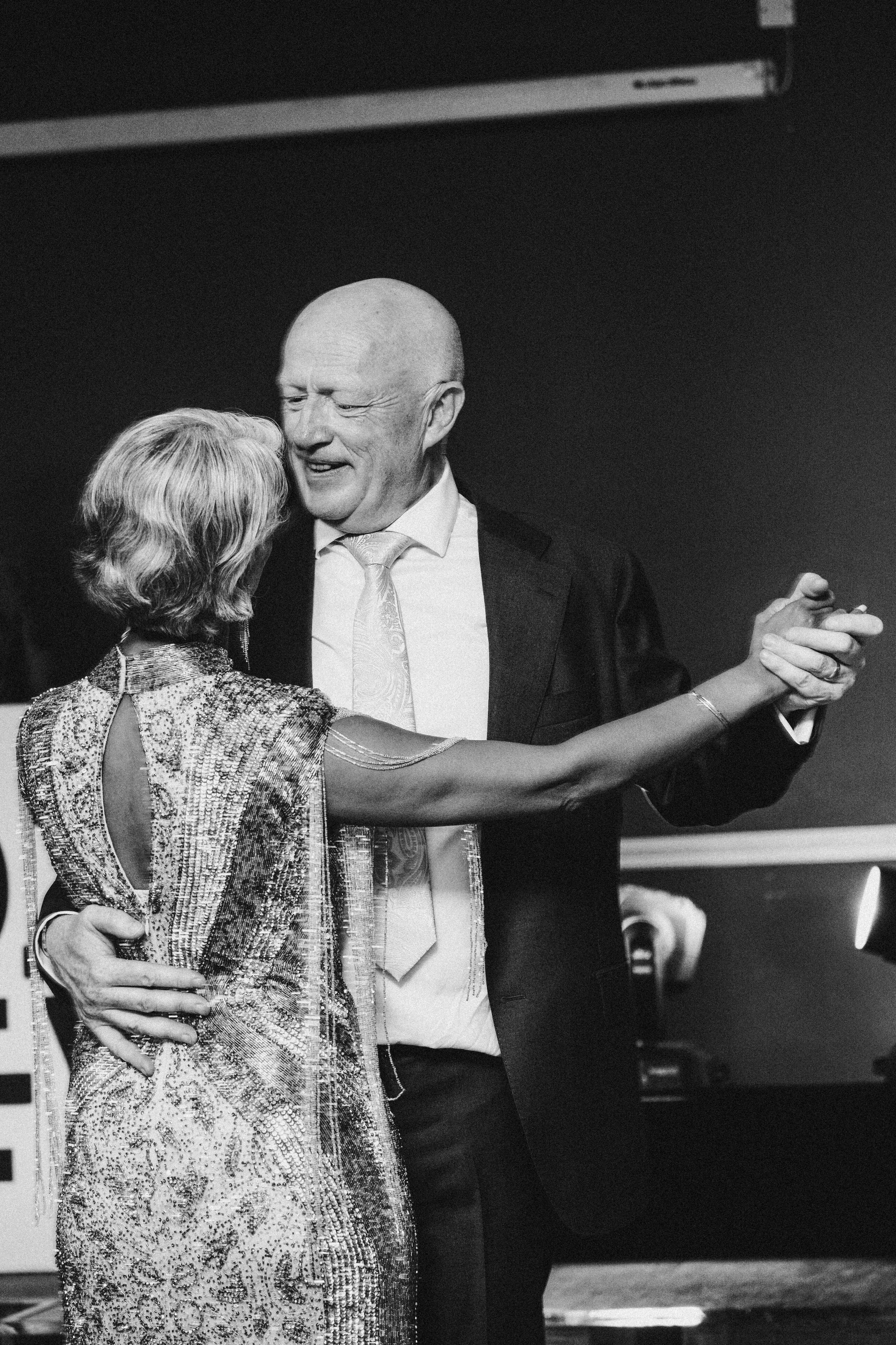 Bride laughing as groom spins her on the dance floor