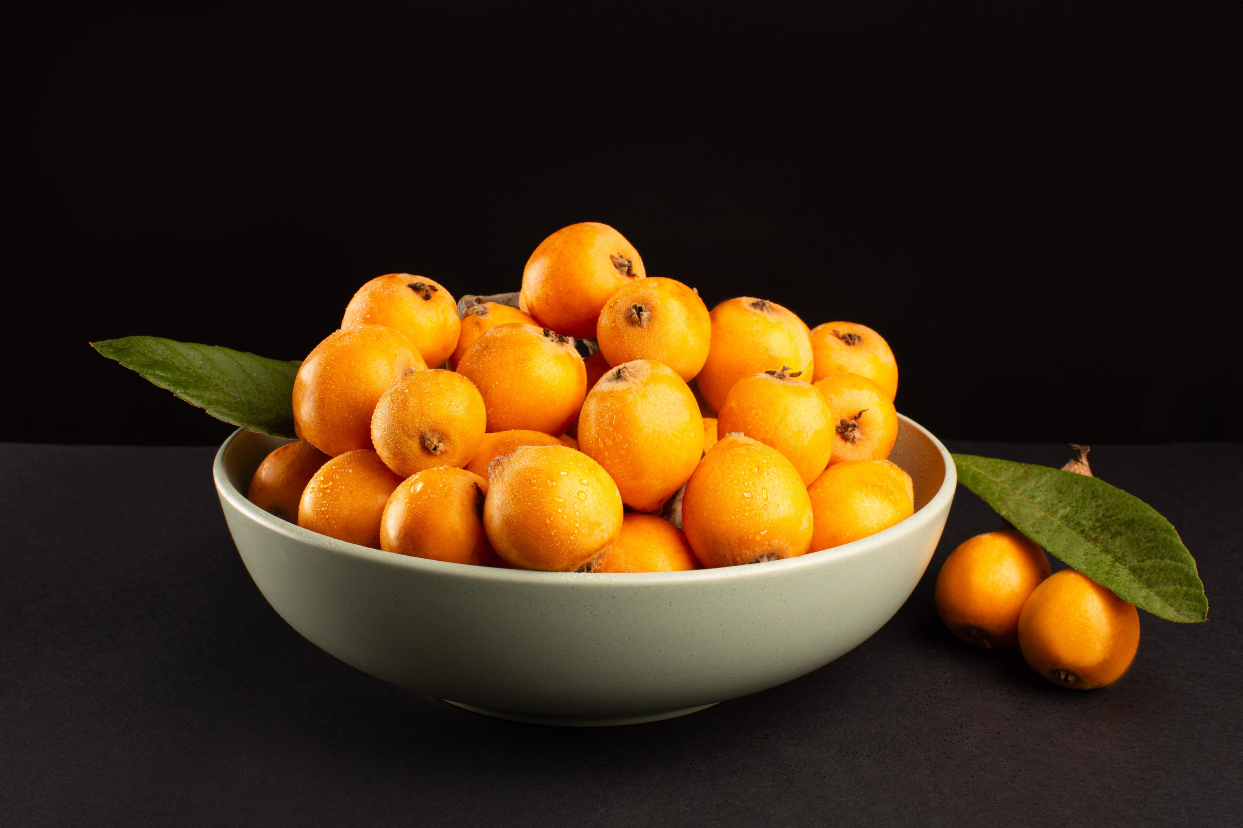 cuenco con naranjas sobre fondo oscuro fotografía de producto