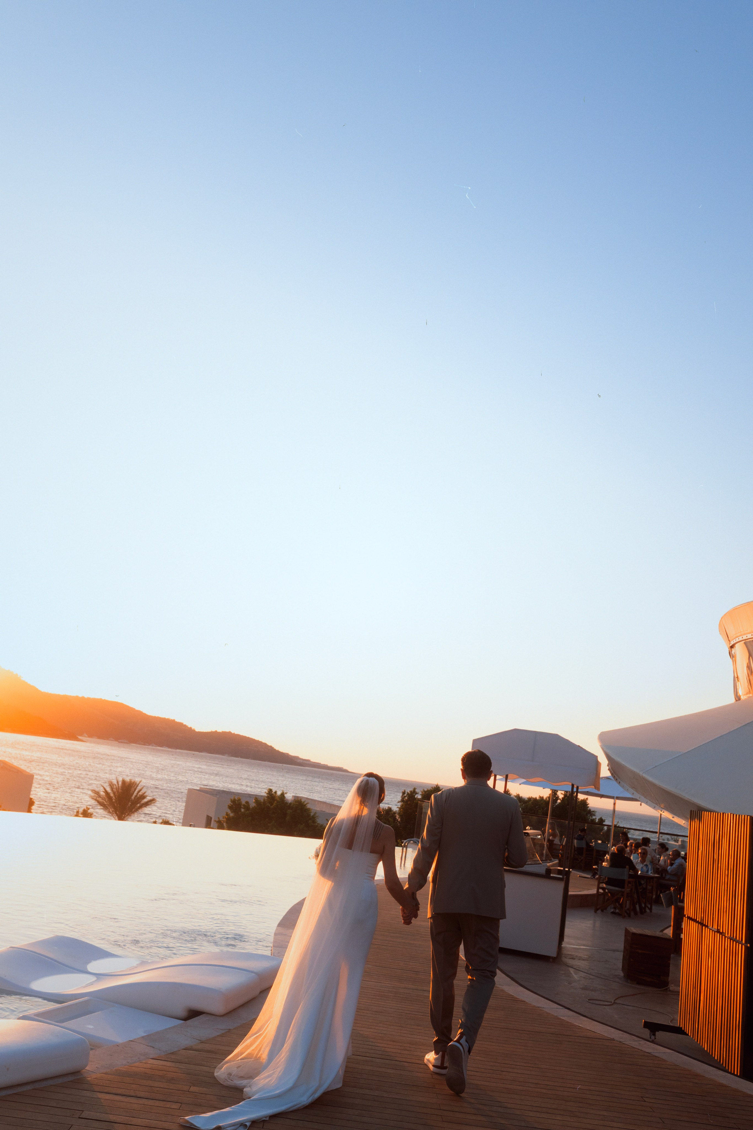 Newlyweds walking together at sunset during their Bodrum wedding