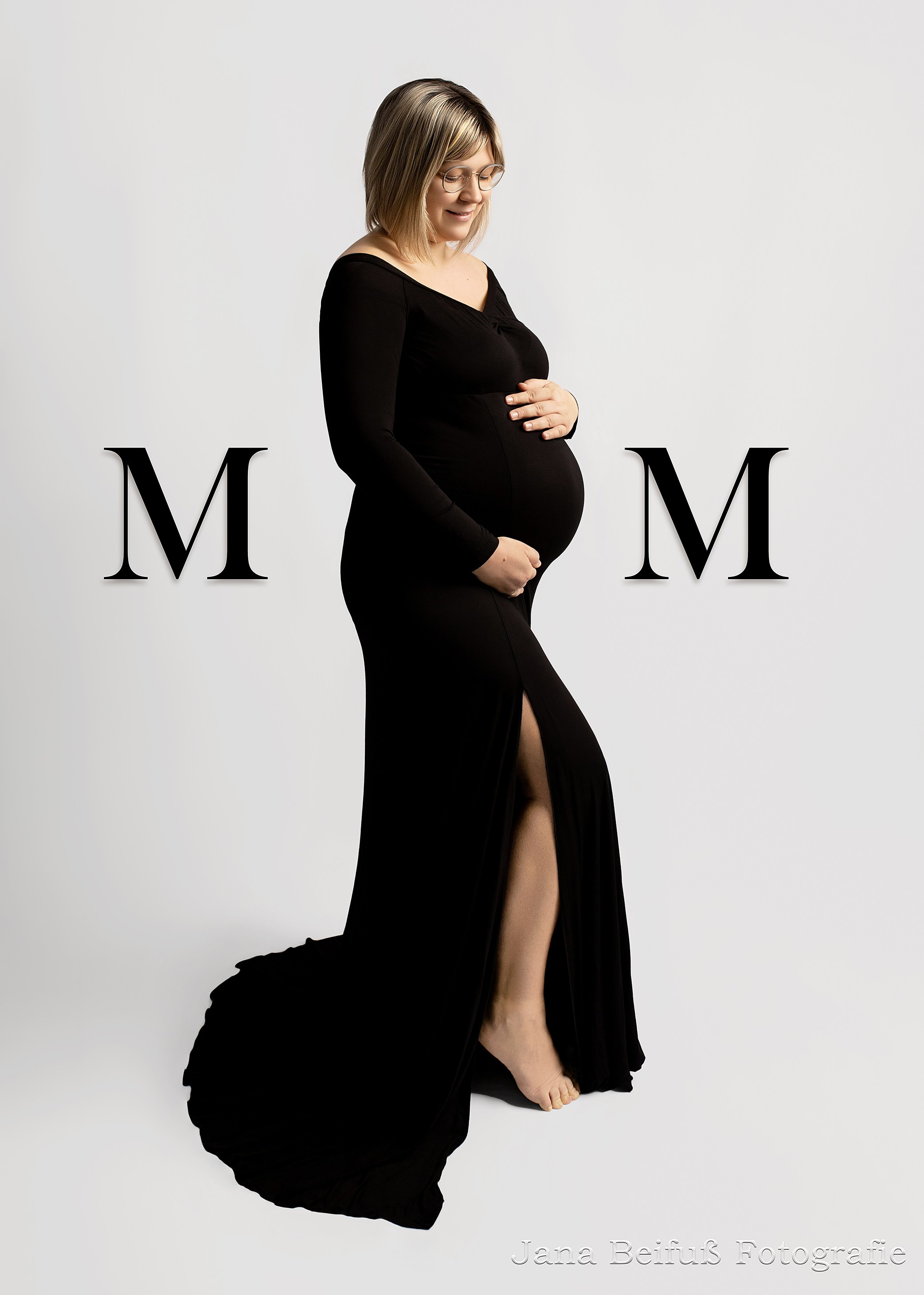 Werdende Mama vor weißem Hintergrund lächelt und schaut auf ihren Bauch bei Jana Beifuß Fotografie in Weißenhorn bei Ulm und Umgebung 