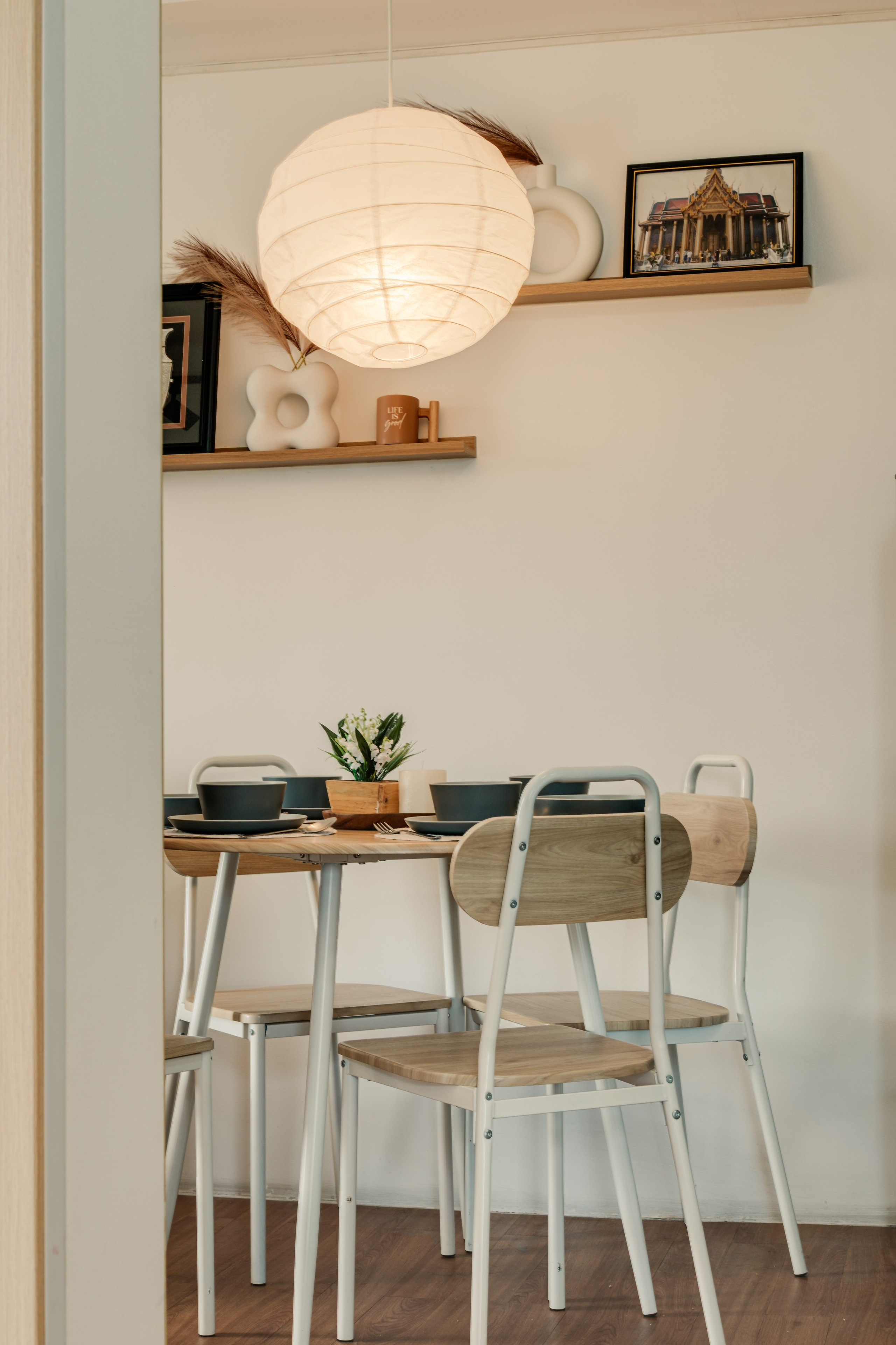 Professional interior photograph of a modern condo featuring a minimalist living room, dining area, warm wood finishes, and soft natural lighting.