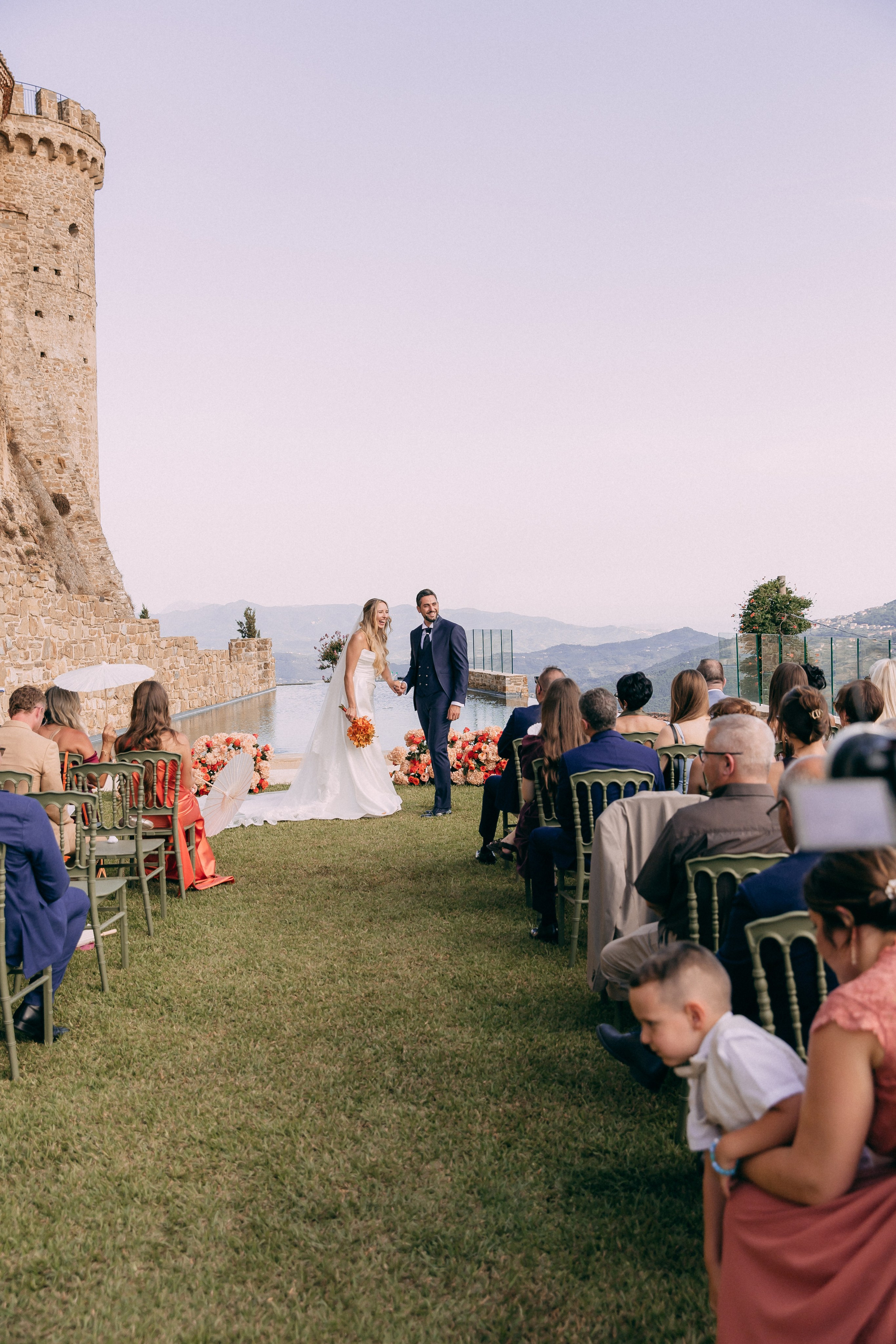 Bride walking down the aisle toward the groom at the castle ceremony