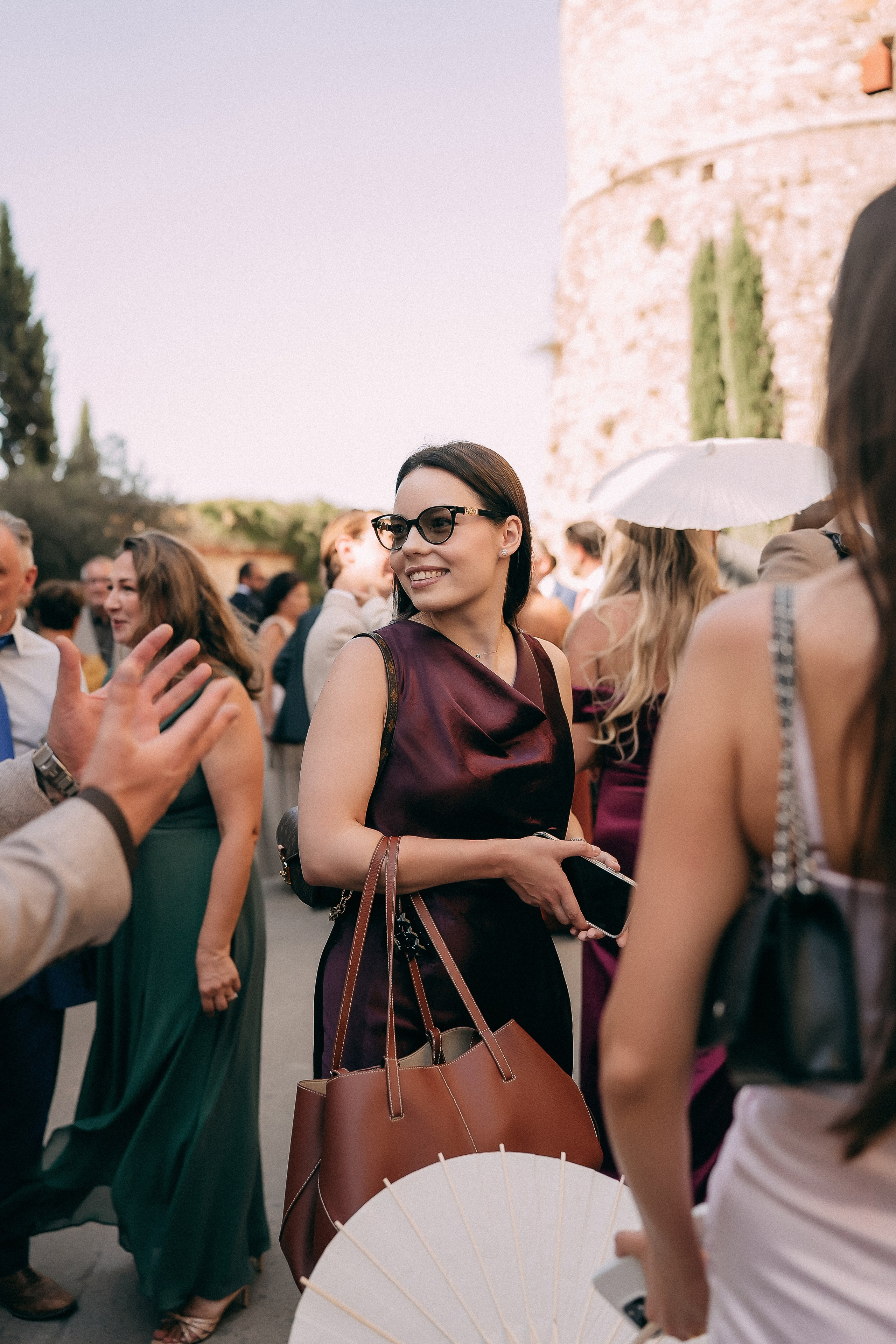 Wedding guests greeting each other with parasols at the castle