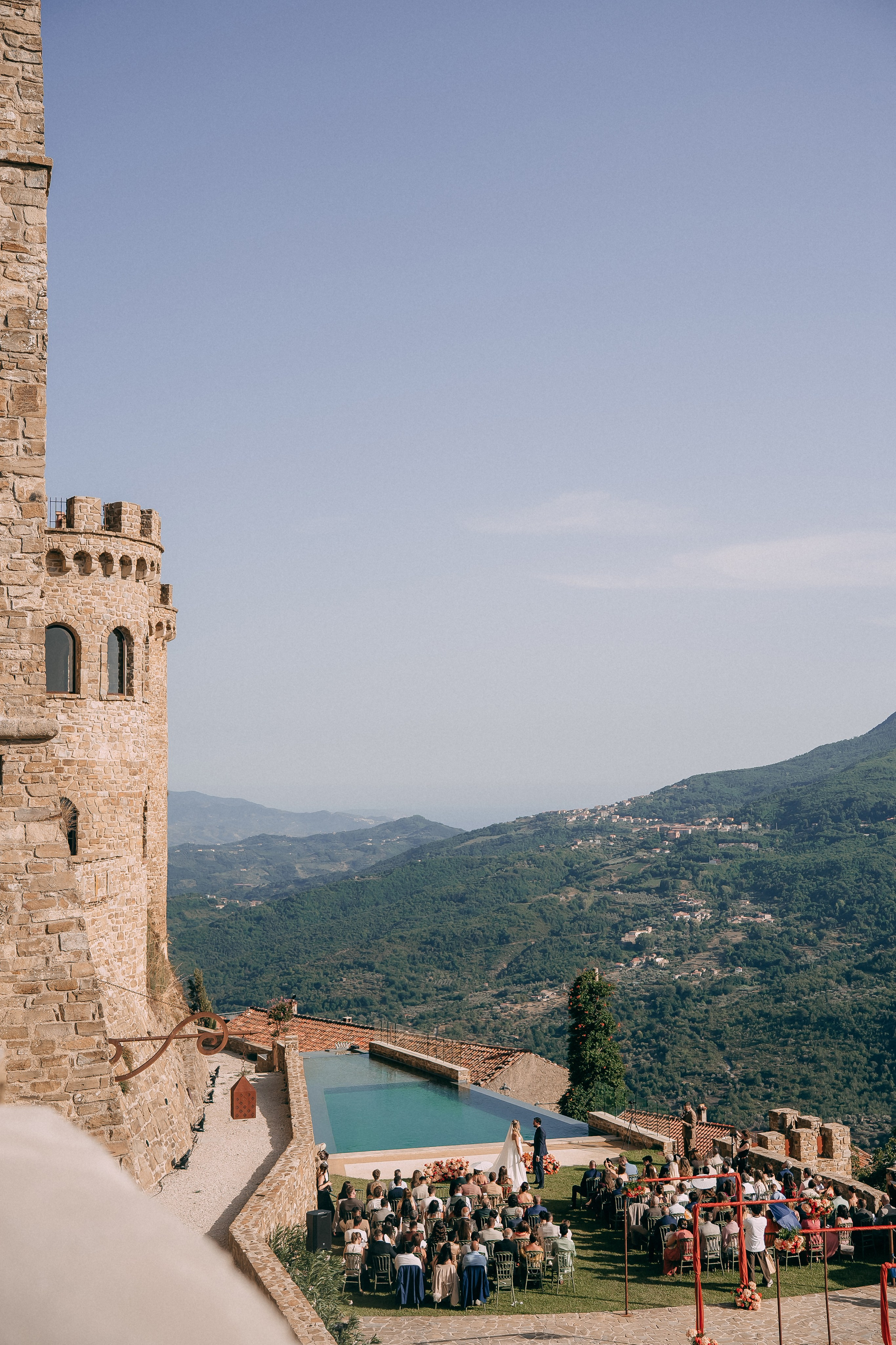 Aerial view of the ceremony by the pool below the castle tower