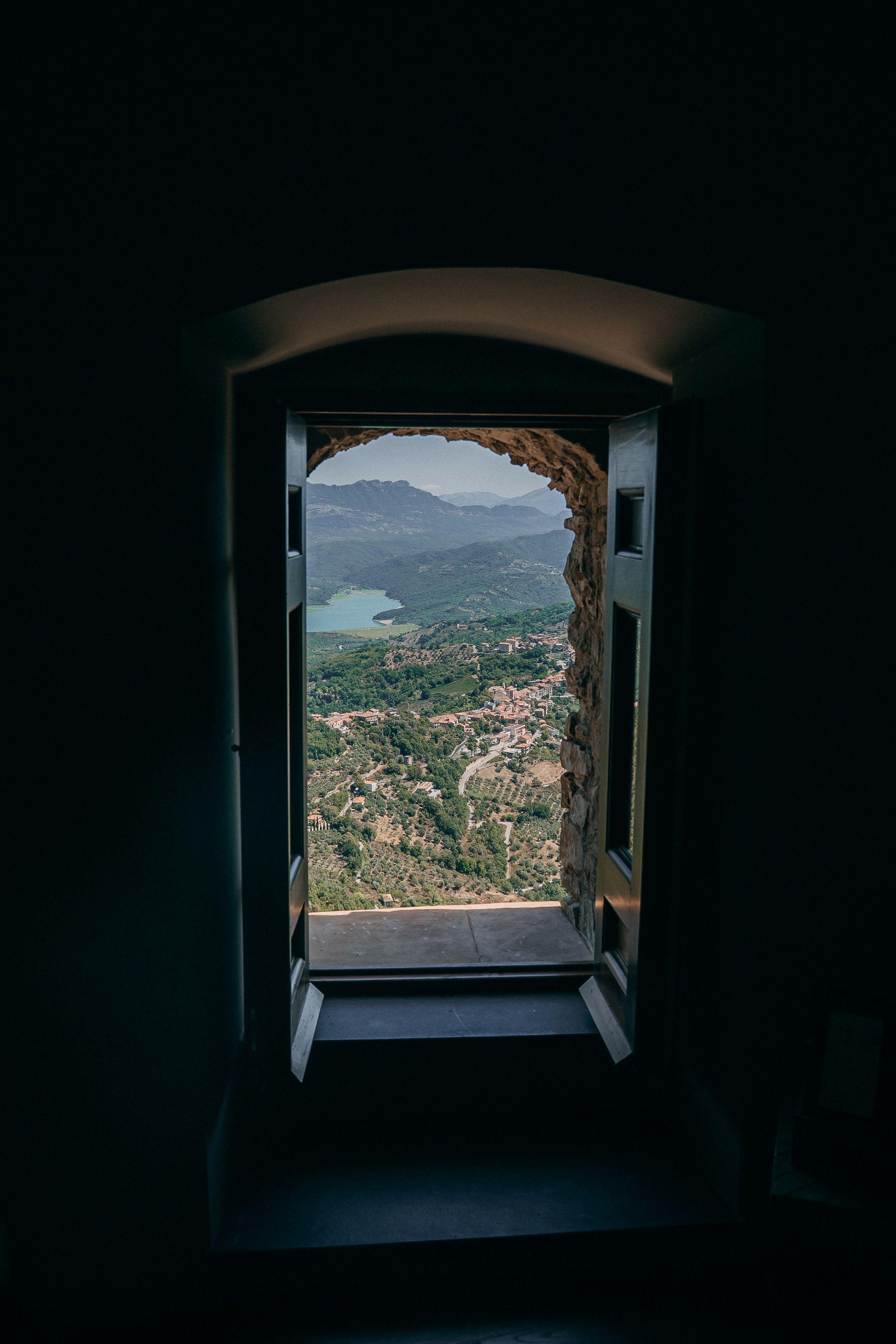 Arched castle window looking out to the valley and lake on the wedding day