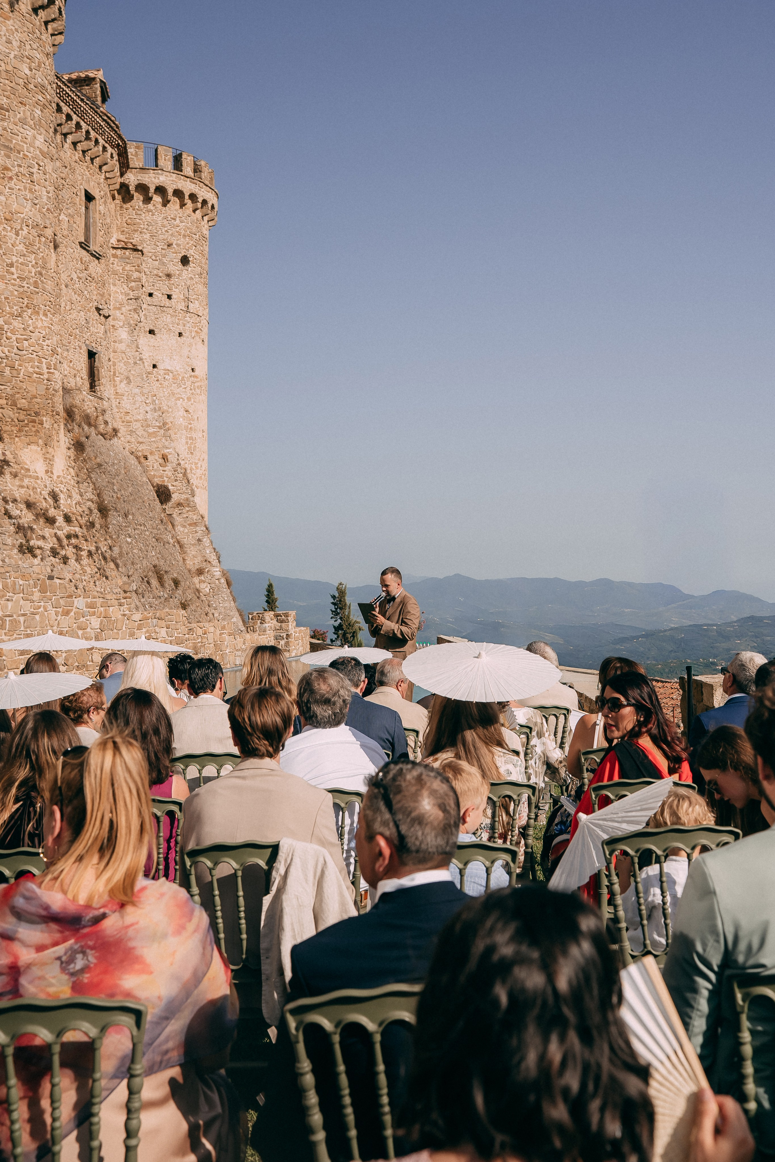 Guests seated for the outdoor ceremony beneath the castle towers